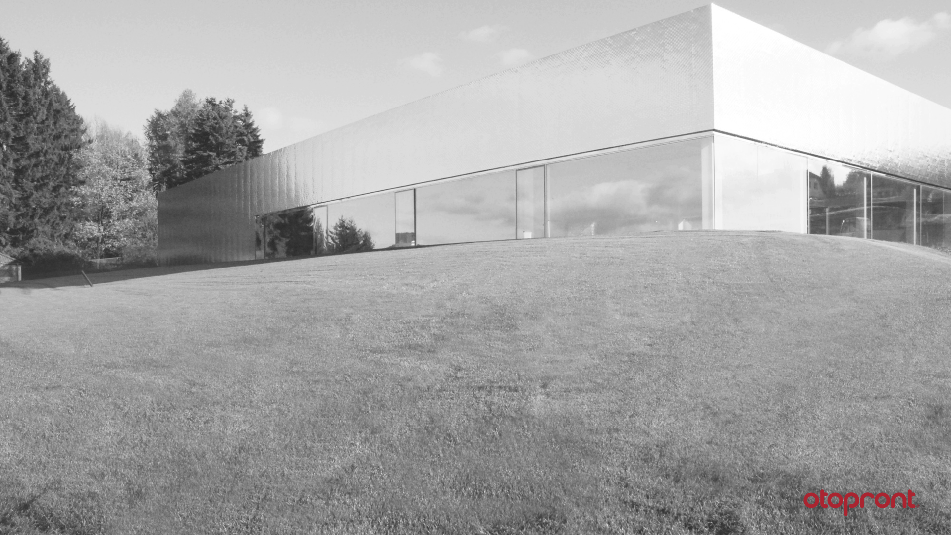 Black and white picture of the exhibition hall from the outside with meadow in the foreground