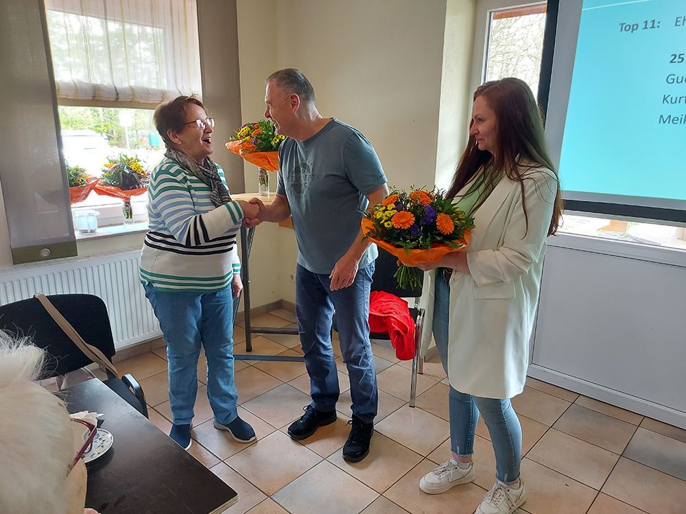 Bildergalerie, Bild 10, Mitgliederversammlung der Reha-Sportgruppe Wardenburg e.V., der Vorsitzende überreicht einem Ehrenmitglied einen Blumenstrauß.