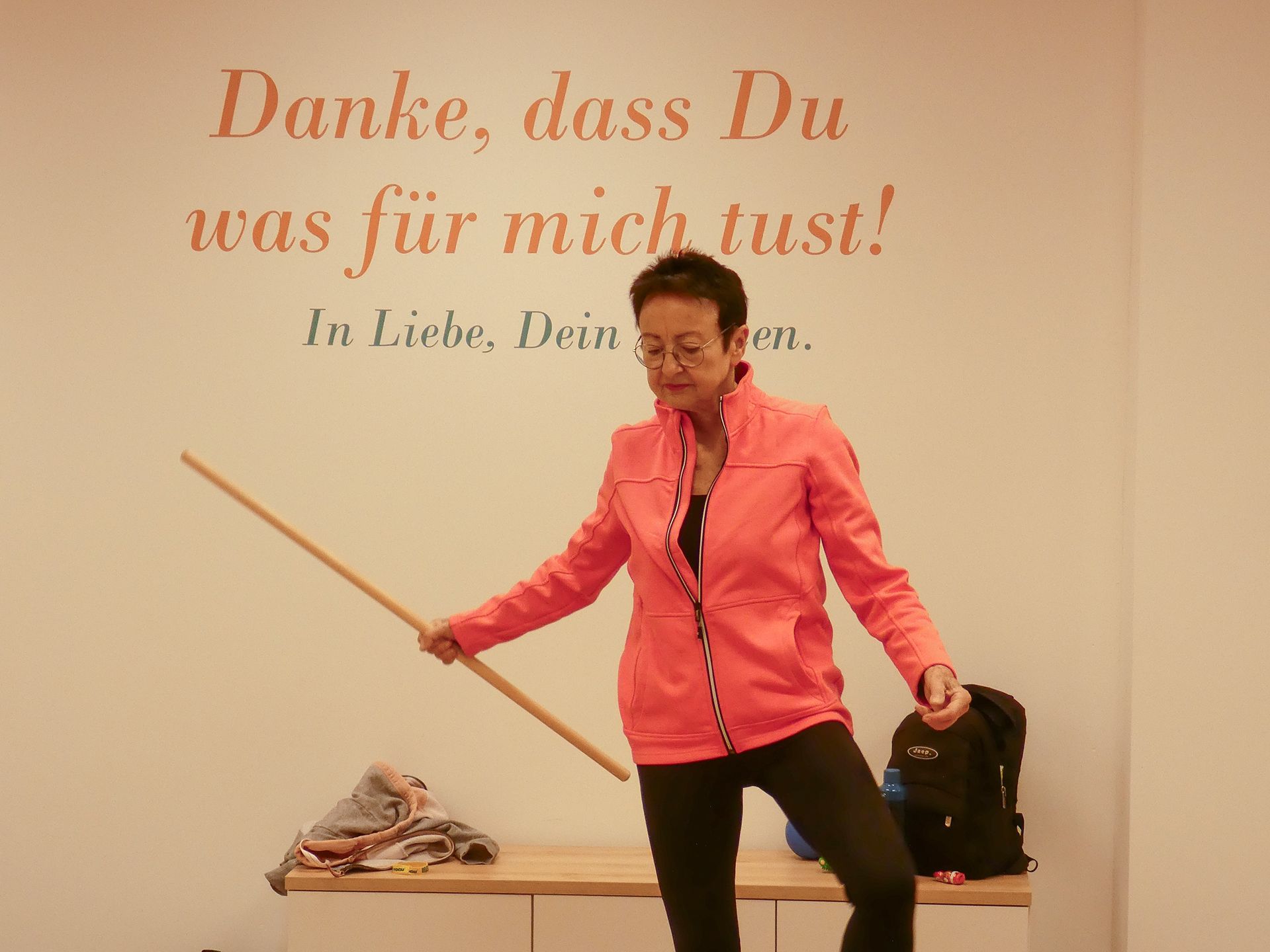 Rückenschule im Seminar- und Bewegungsraum der Reha-Sportgruppe Wardenburg. Eine Teilnehmerin übt mit einer Stange.