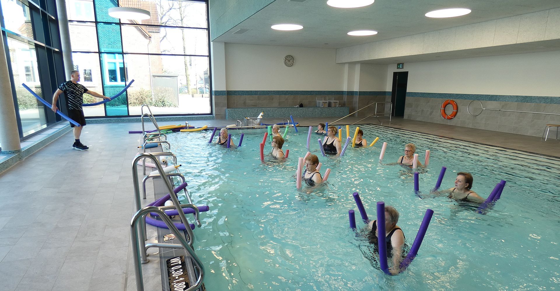 Wassergymnastik in der Schwimmhalle in Wardenburg. Eine Gruppe Frauen übt mit Poolnudeln.