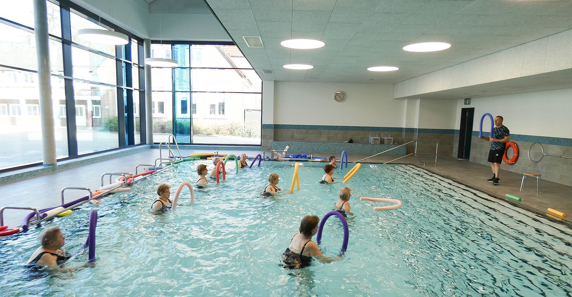 Wassergymnastik in der Schwimmhalle in Wardenburg. Eine Gruppe Frauen übt mit Poolnudeln.