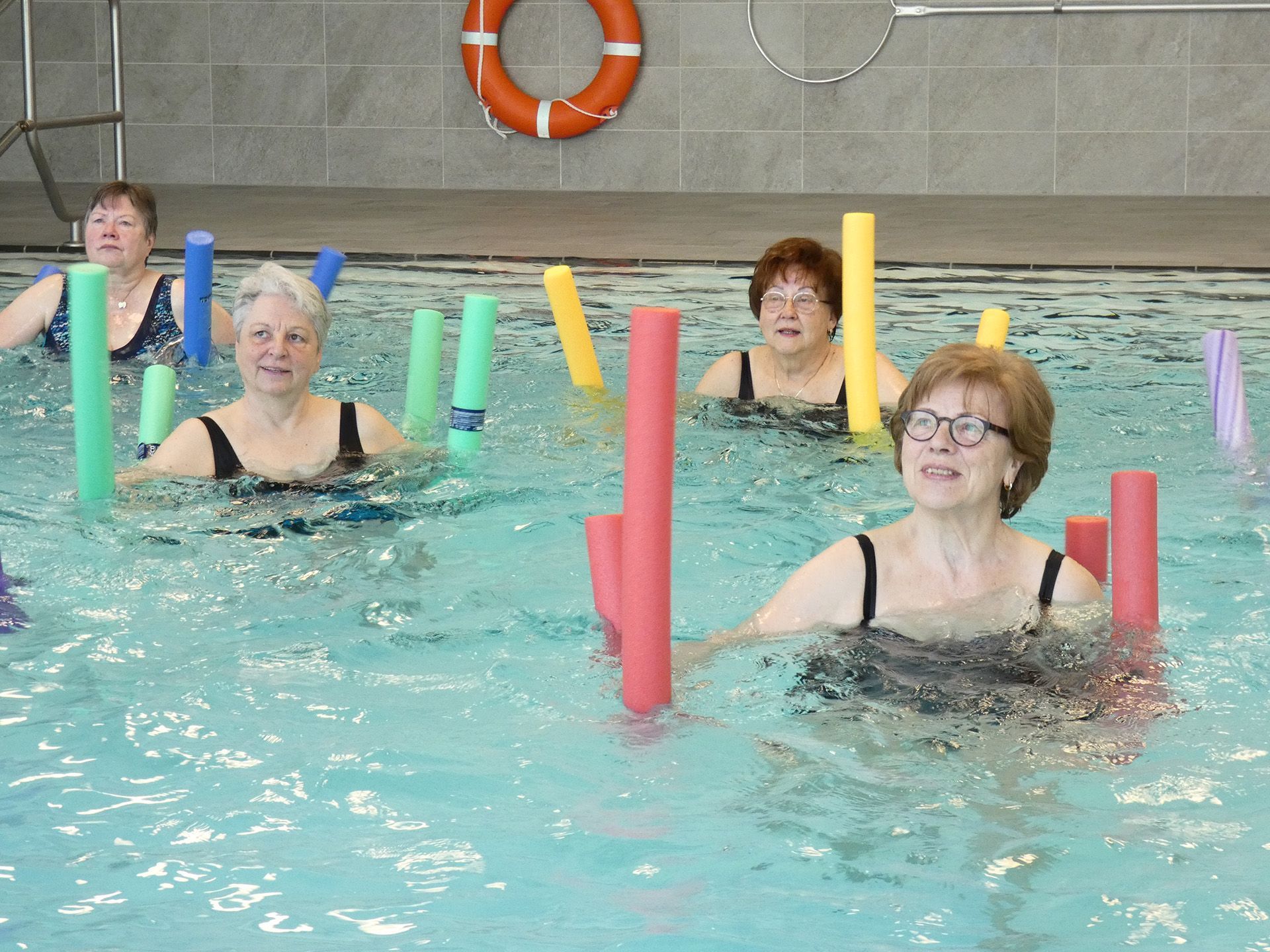 Wassergymnastik in der Schwimmhalle in Wardenburg. Eine Gruppe Frauen übt mit Poolnudeln.