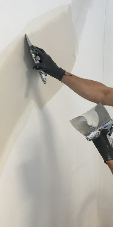 Un peintre répare un dégât des eaux après une fuite d'eau au plafond