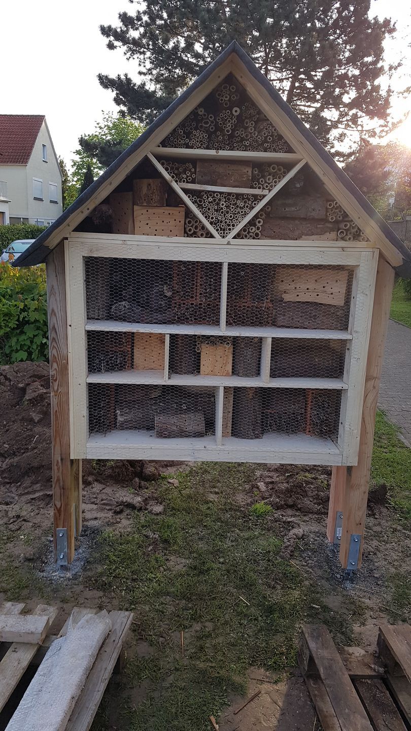 Ein Insektenhotel aus Holz in der Form eines Häuschens Ein Insektenhotel aus Holz in der Form eines Häuschens