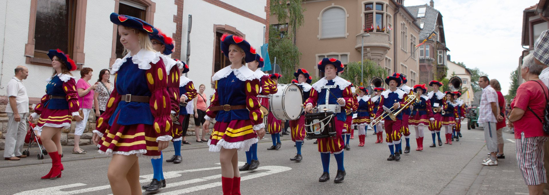 Ein Musik während eines Umzugs mit Publikum am Straßenrand