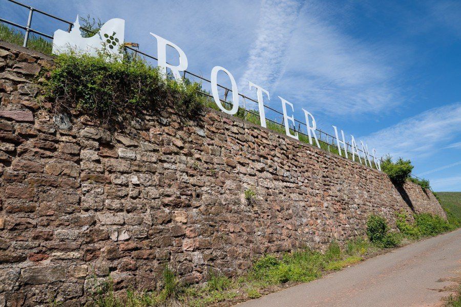 Natursteinmauer im Weinberg an der oberen Kante der Schriftzug roter Hang als dreidimensionale Buchstaben Natursteinmauer im Weinberg an der oberen Kante der Schriftzug roter Hang als dreidimensionale Buchstaben