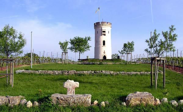 Schlossturm mit Umgebung, blauem Himmel und Sandsteinfragmenten im Vordergrund