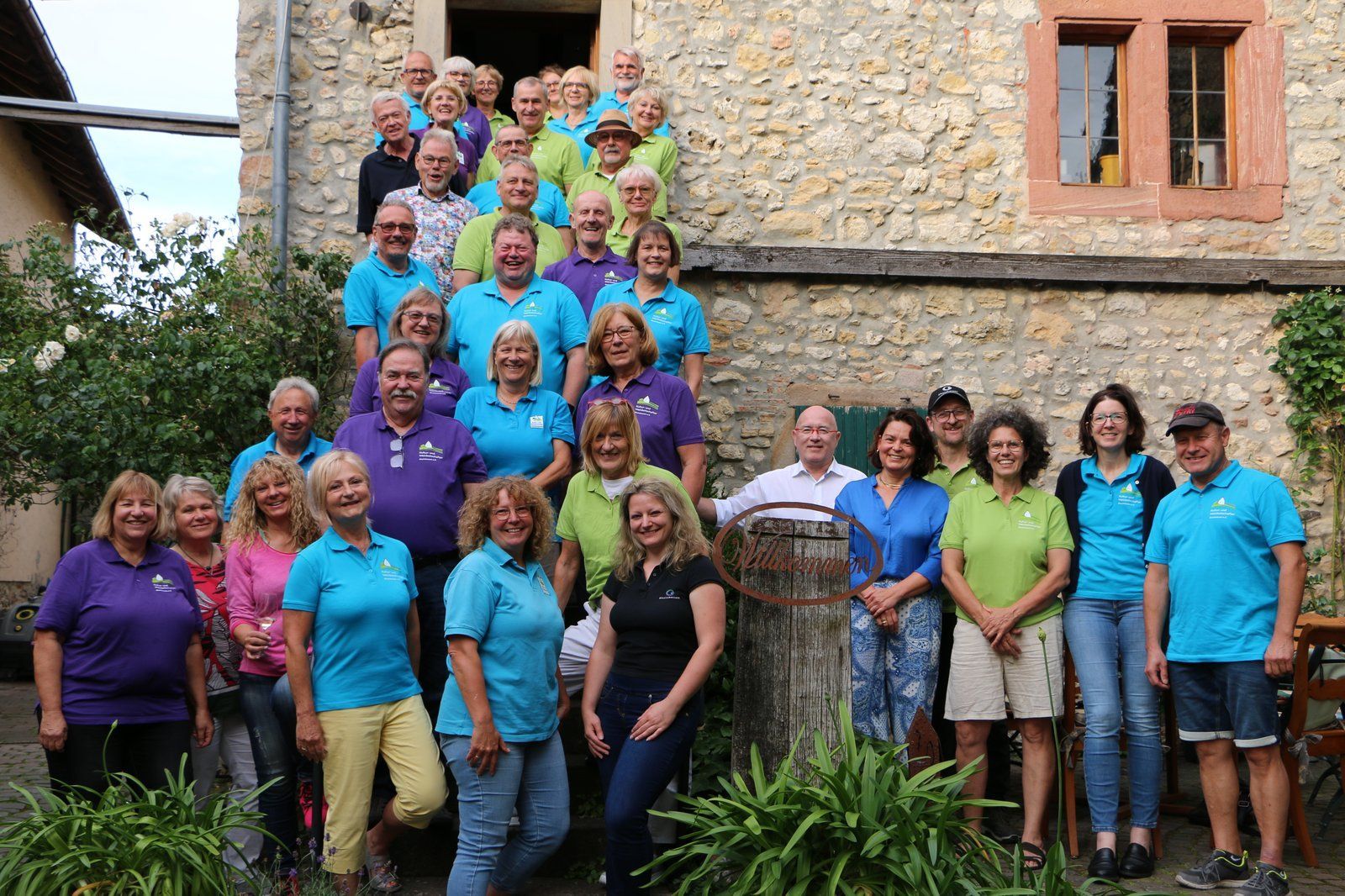 Die Kultur und Weinbotschafter Rheinhessens stehen auf einer Treppe vor einem Bruchsteinhaus. Es sind ca. 25 Personen. Die Kultur und Weinbotschafter Rheinhessens stehen auf einer Treppe vor einem Bruchsteinhaus. Es sind ca. 25 Personen.