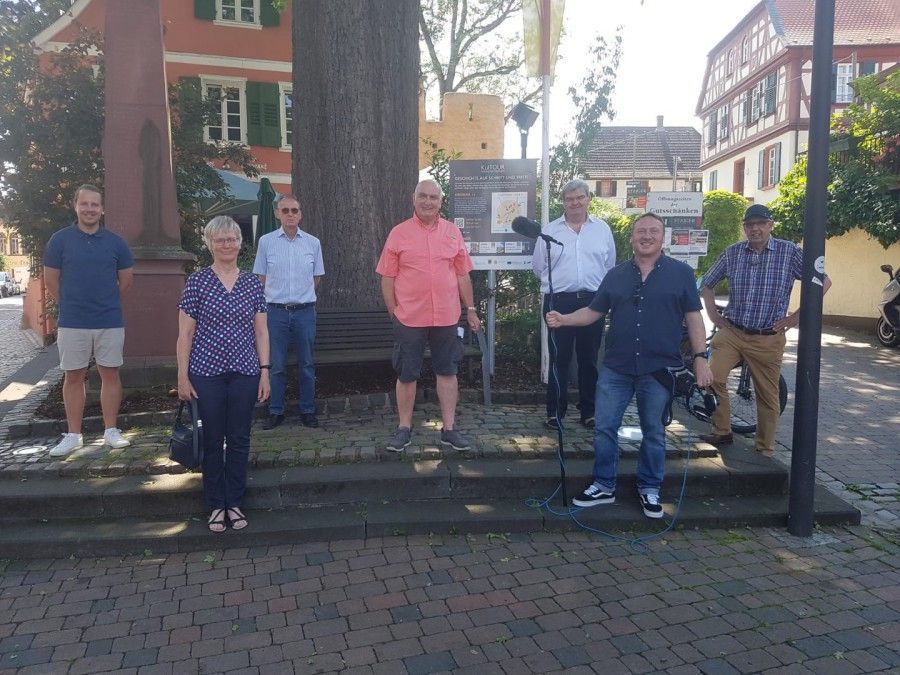 Sieben Personen stehen vor dem Schild welches den QR Code für die KulTOUR enthält Sieben Personen stehen vor dem Schild welches den QR Code für die KulTOUR enthält
