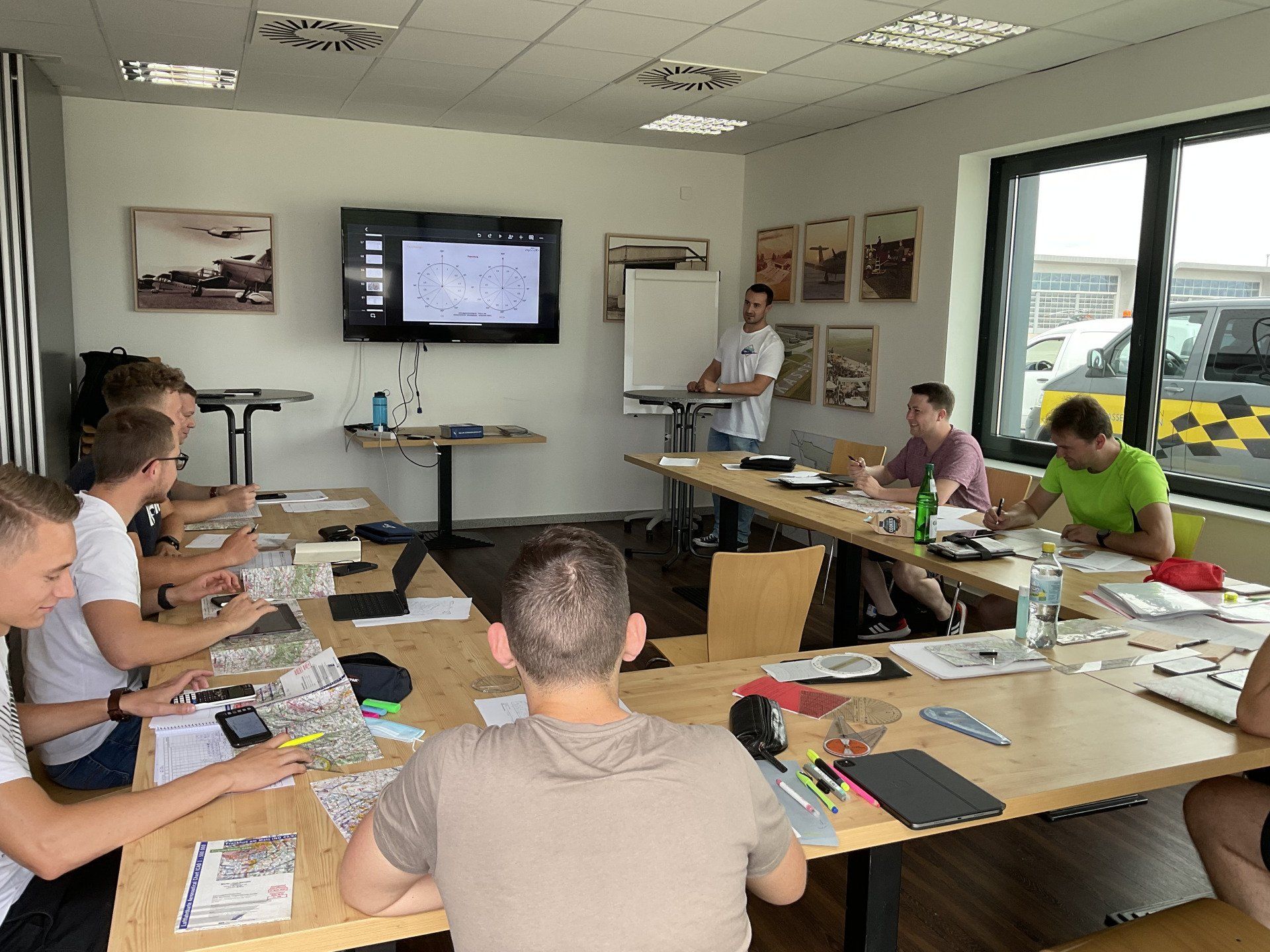 Unterrichtsraum mit Flugschülern bei der Flugplanung Lehrer erklärt Flugplanung