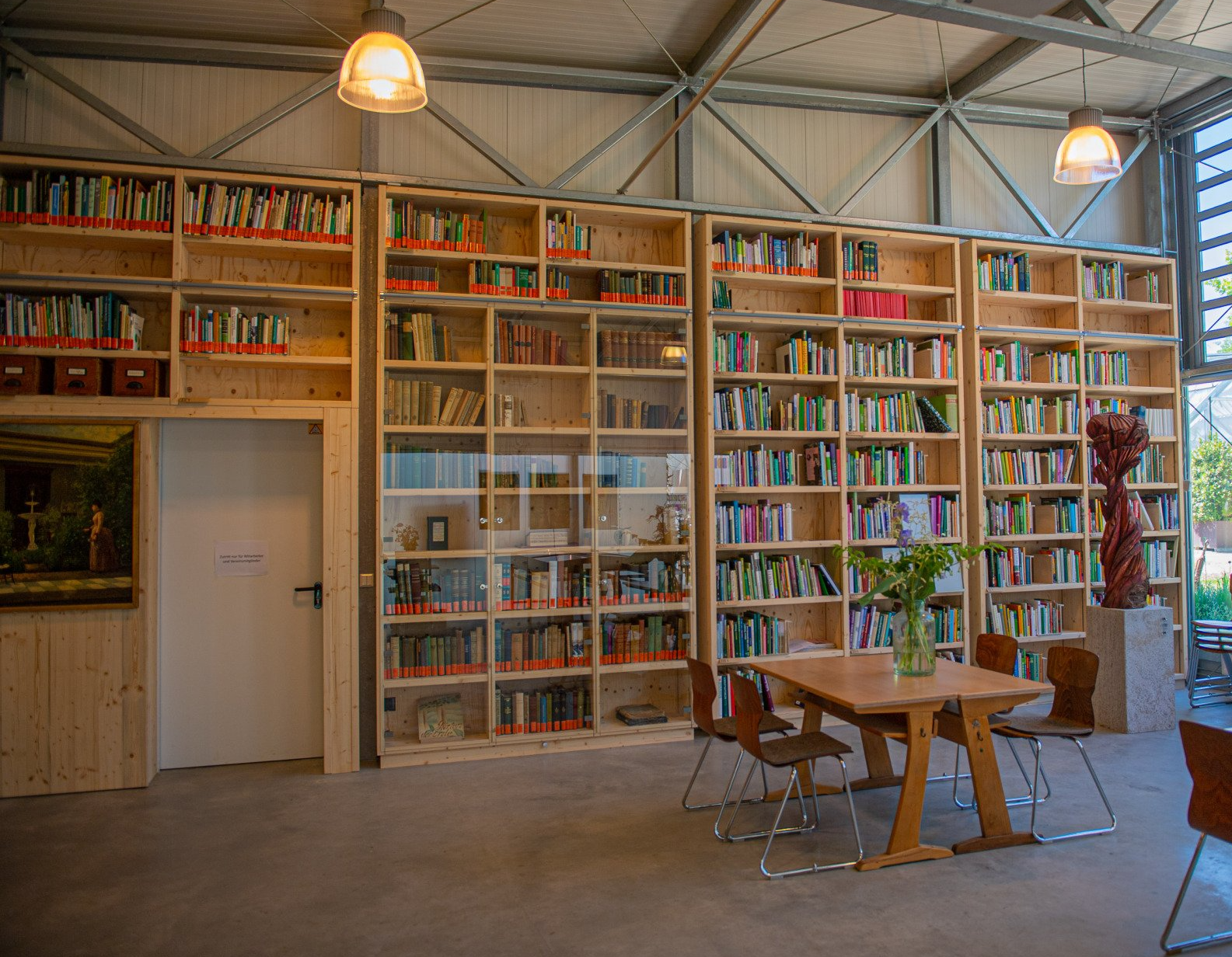 Blick in die Gartenbibliothek, in der Mitte die Vitrine mit historischen Gartenbüchern. Foto: WTO Blick in die Gartenbibliothek mit umlaufenden Bücherregalwänden. In der Mitte die Vitrine mit den historischen Gartenbüchern
