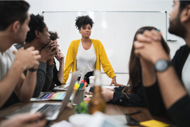 Une femme leader s'adressant à son équipe lors d'une réunion.