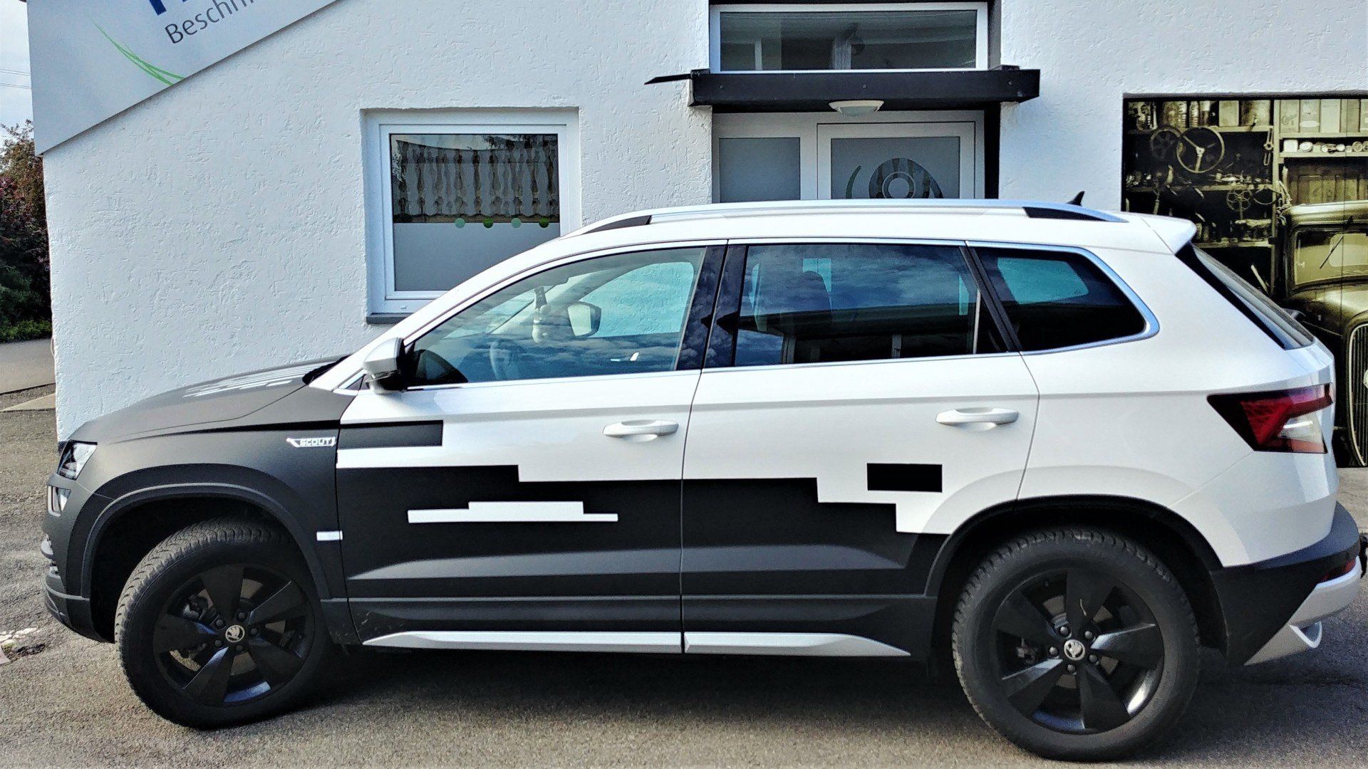 Schwarz-matt teilfoliert.