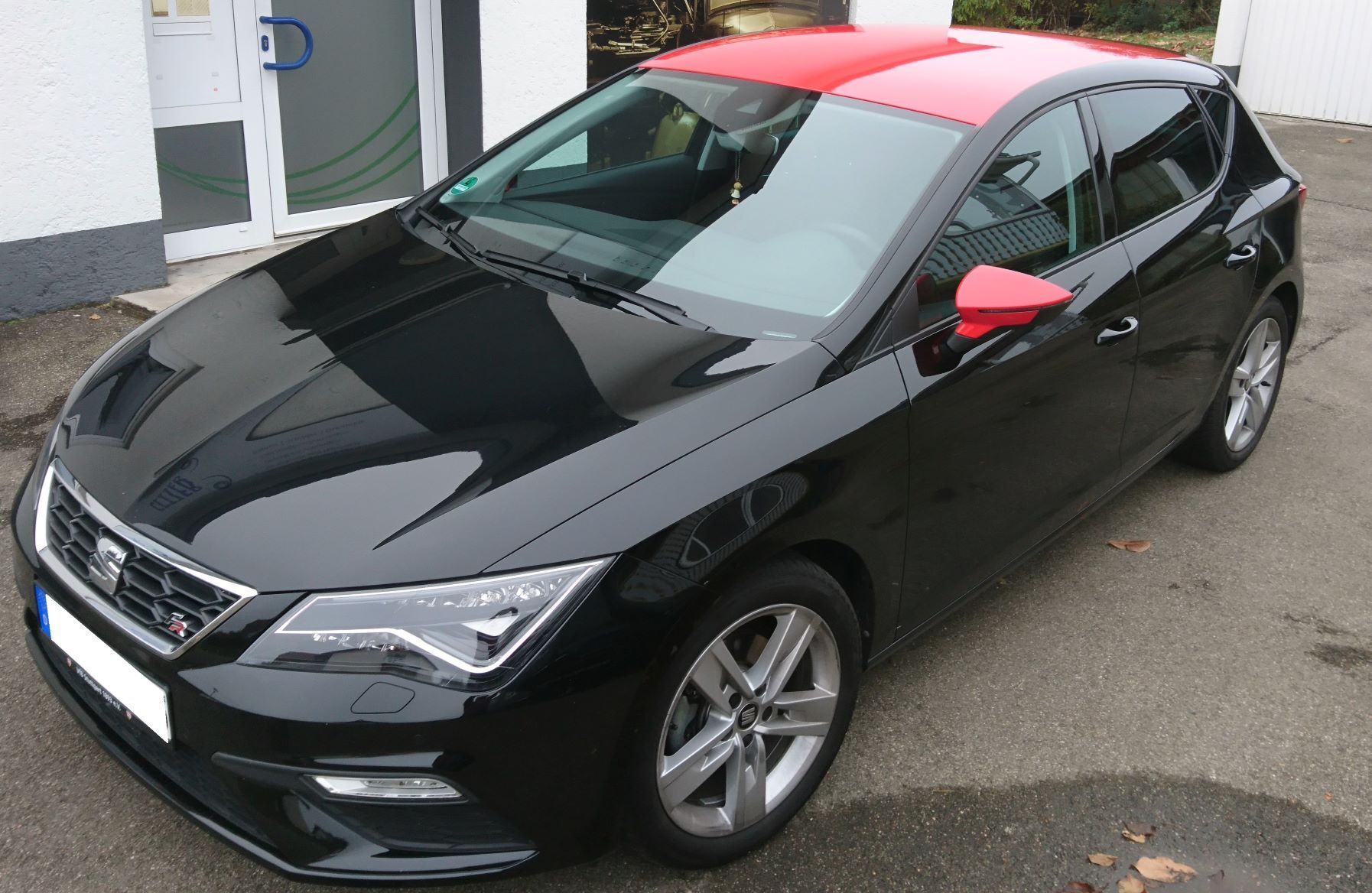 Fahrzeugdach und Spiegel mit roter Folie eingezogen.