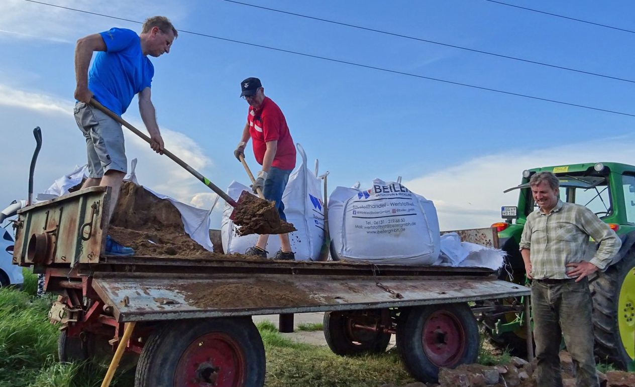 Michael Schuhknecht und Jörg Leinekugel leeren die Sandsäcke und verfüllen die Grube für die Erdbienen