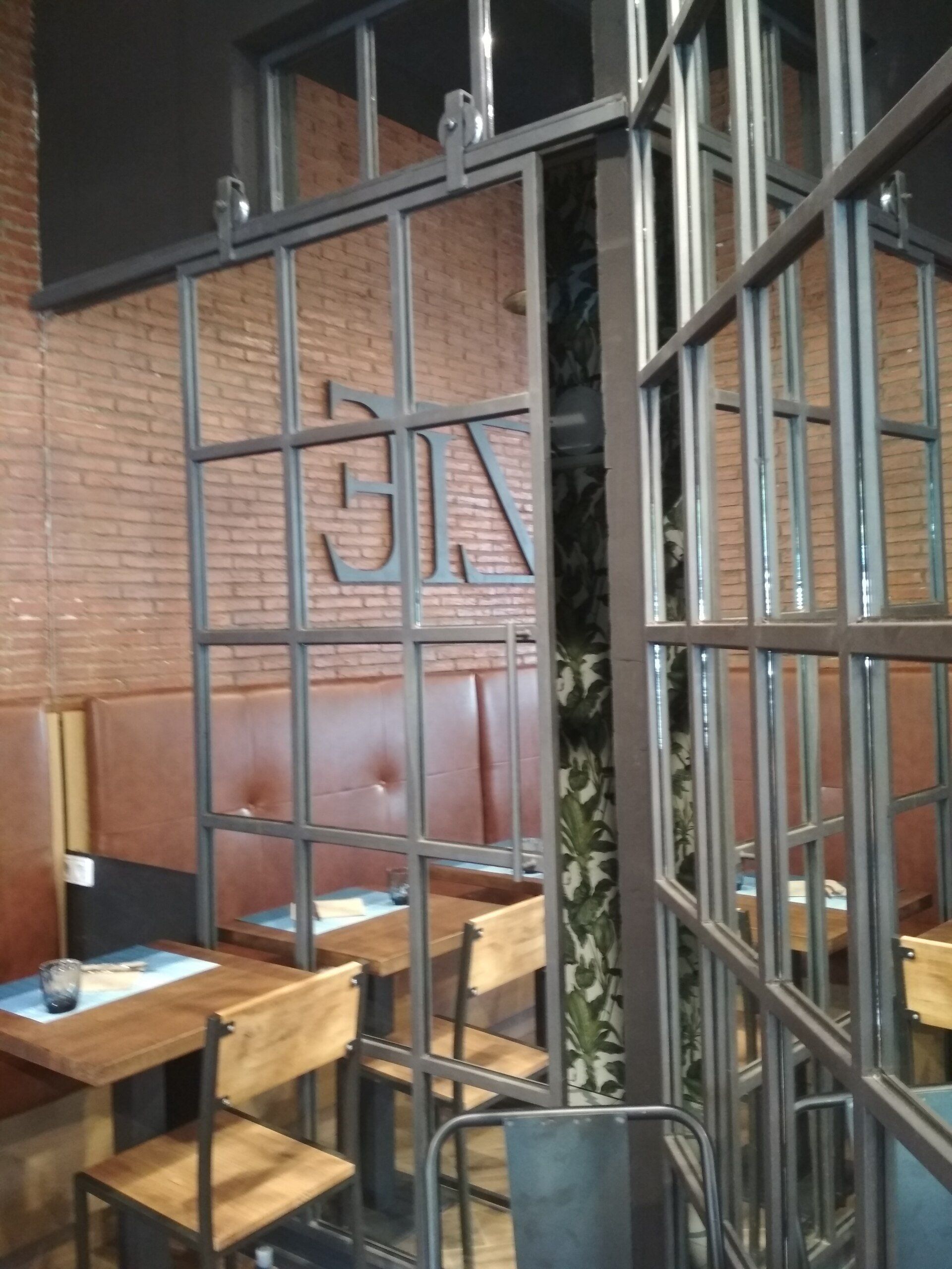 Proyecto de Interiorismo para gastro-cafetería en Plaza Letamendi en Barcelona, local en planta baja de 40m2, realizado diseño y seguimiento y coordinación de obra. Se hace redistribución del espacio con máxima optimización. Mobiliario, barra y decoración en forja y espejo. Alicatados y pared de ladrillo visto.