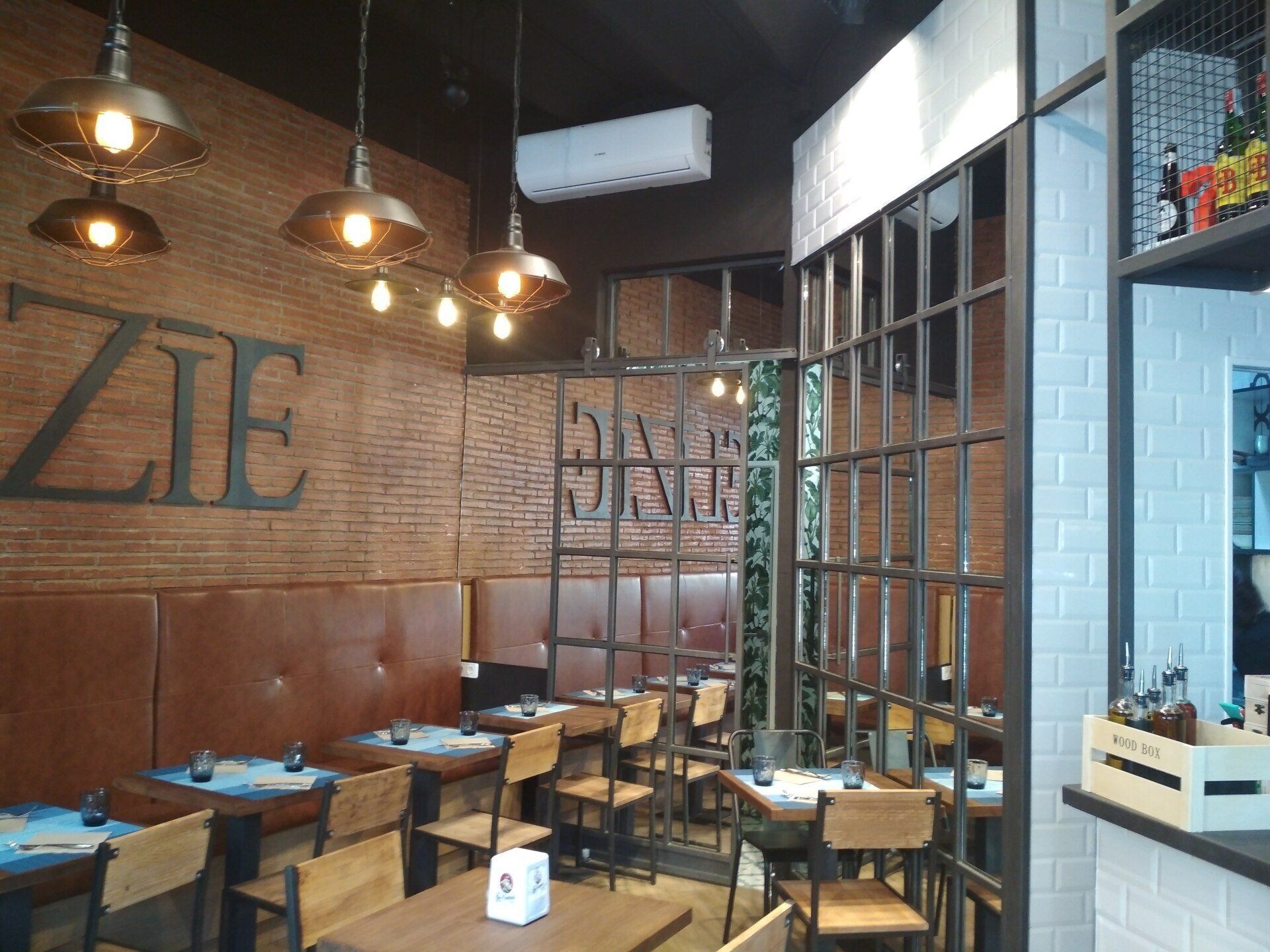 Proyecto de Interiorismo para gastro-cafetería en Plaza Letamendi en Barcelona, local en planta baja de 40m2, realizado diseño y seguimiento y coordinación de obra. Se hace redistribución del espacio con máxima optimización. Mobiliario, barra y decoración en forja y espejo. Alicatados y pared de ladrillo visto.