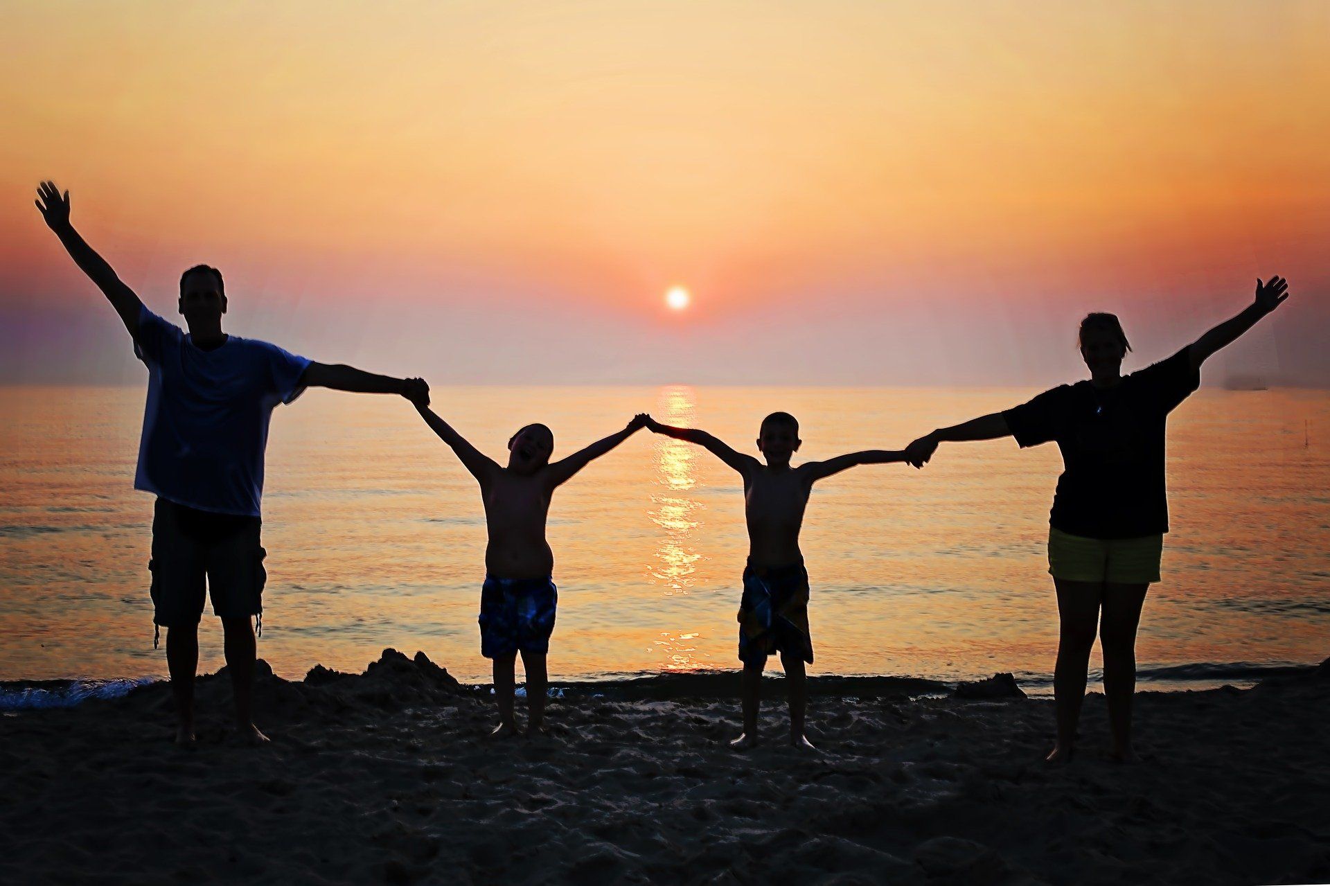Glückliche Familie vor einem Sonnenaufgang nach der Erziehungsberatung und psychologische Hilfe für die Familie