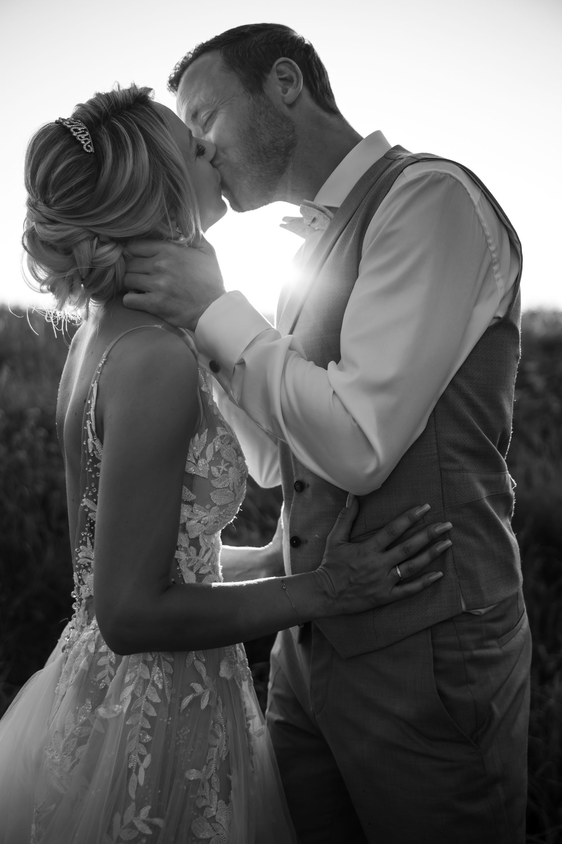 Brautpaar steht abends bei Sonnenuntergang mit Brautkleid und Hochzeitsanzug für Brautpaarshooting bereit