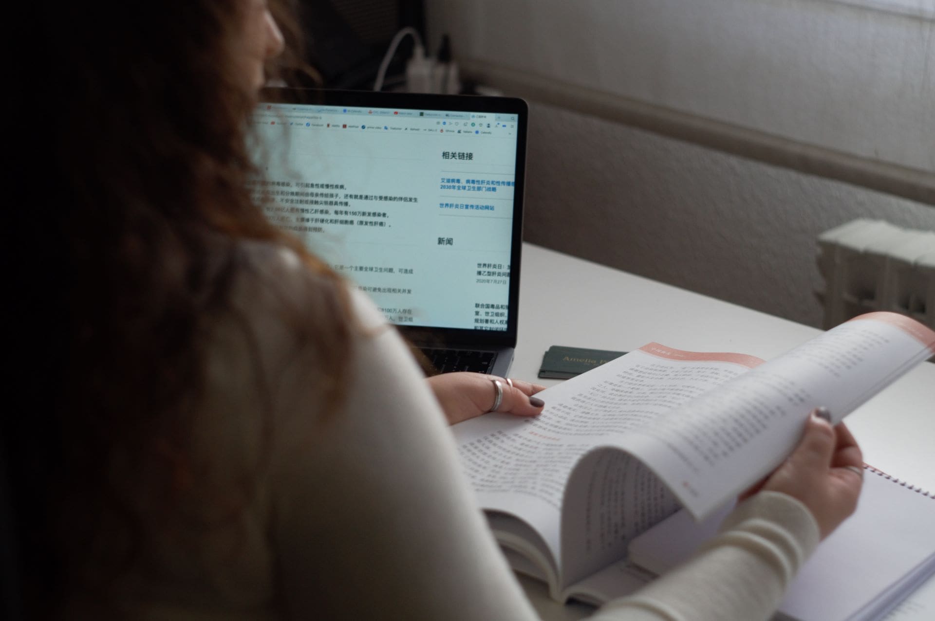 Amelia traduciendo con un portátil y un libro en chino