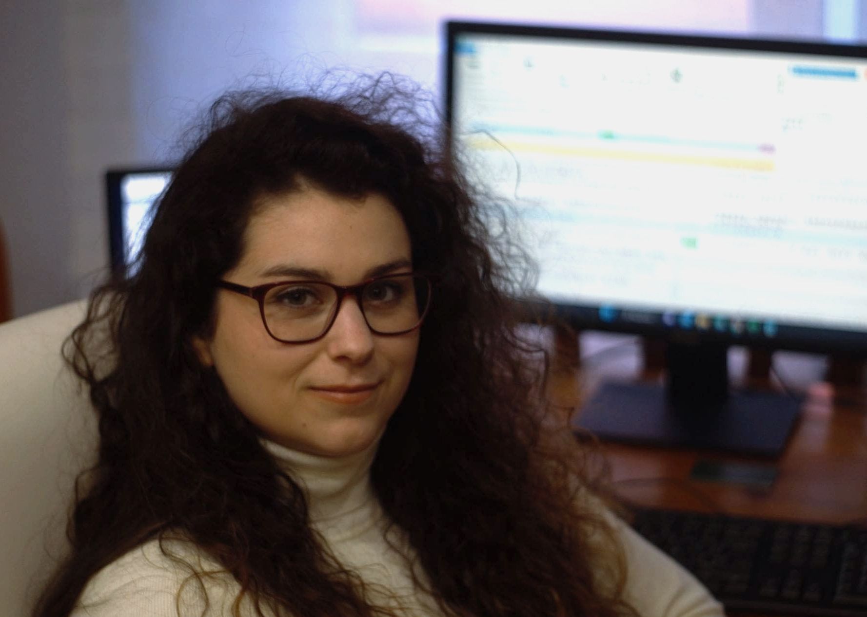 Foto de Amelia sonriendo frente a un monitor