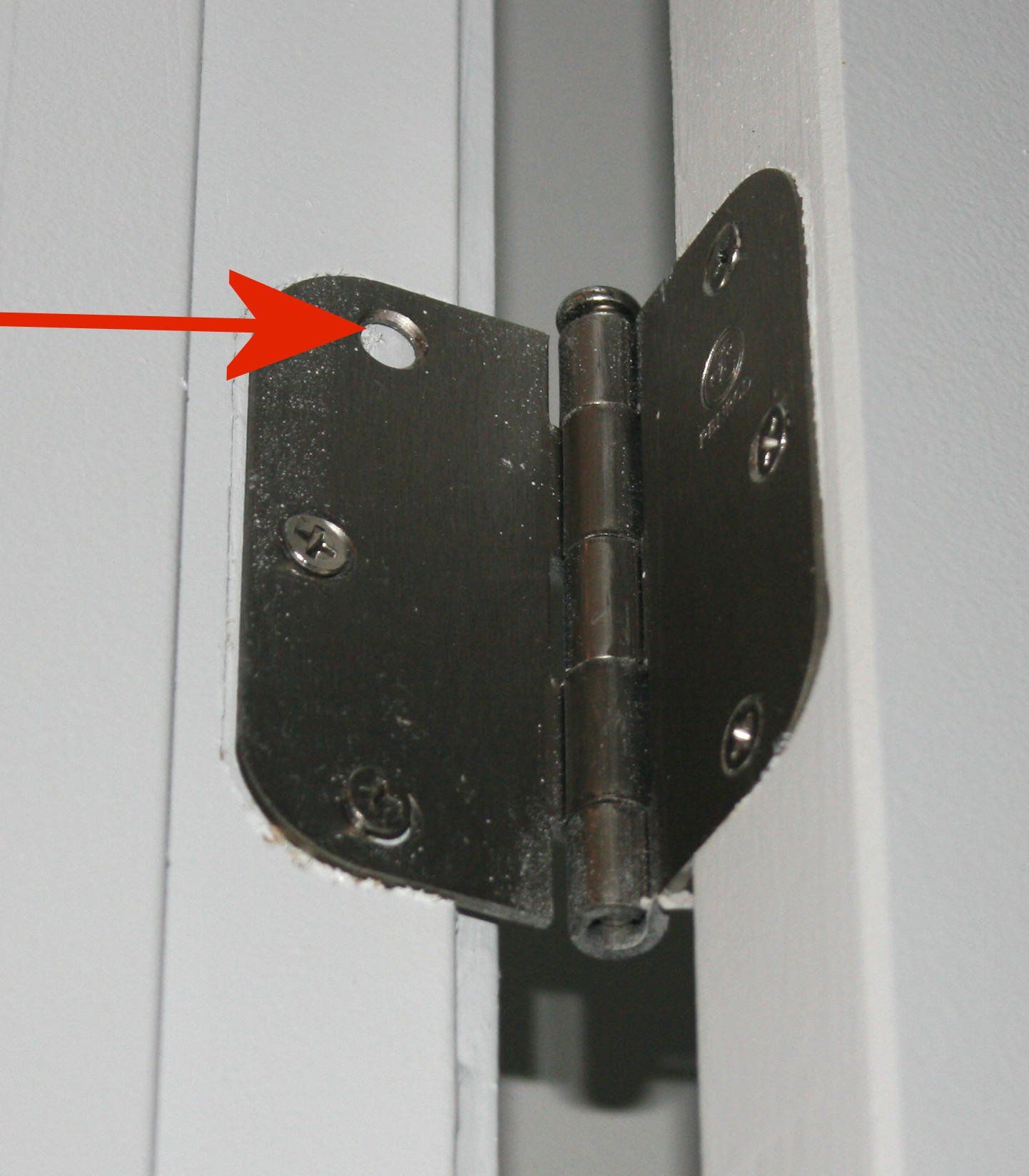 Missing screw from an interior door hinge shows the lack of attention to detail in this Kolter home.