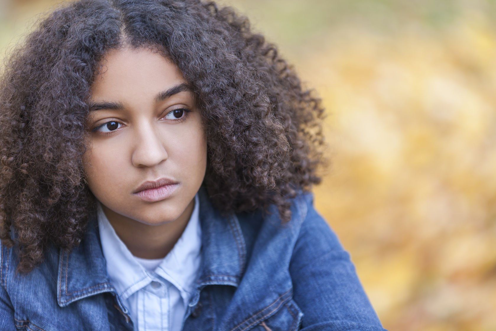 Photo of a young Black girl in a denim jacket.
