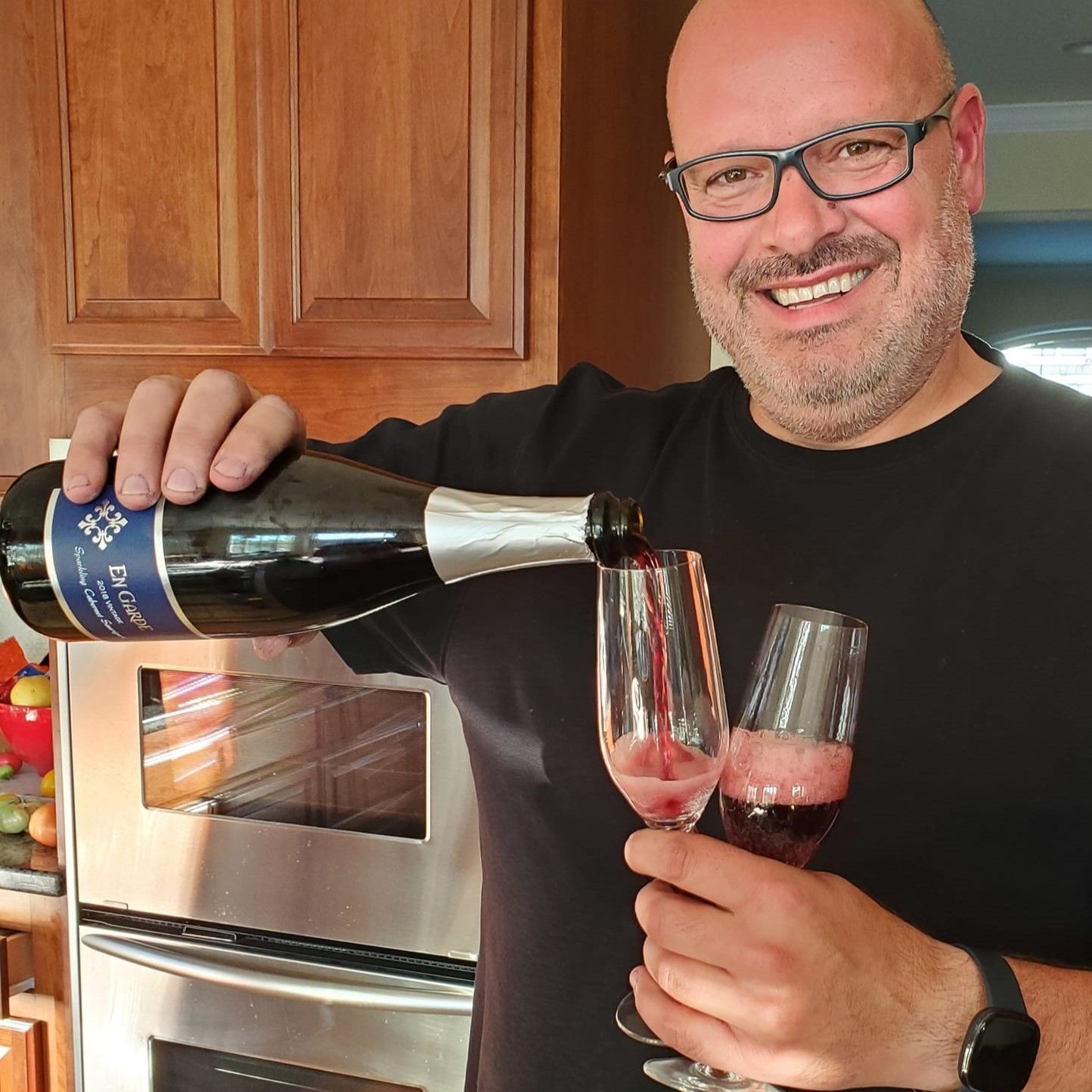 Csaba pouring a glass of red champagne