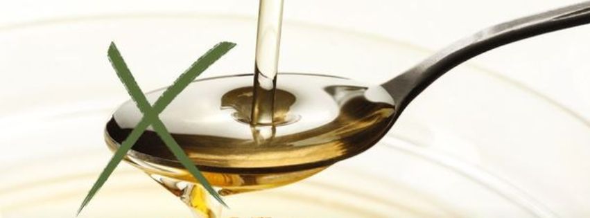 Image of liquid oil poured over a spoon, with a cross indicating it's wrong to feed to horses