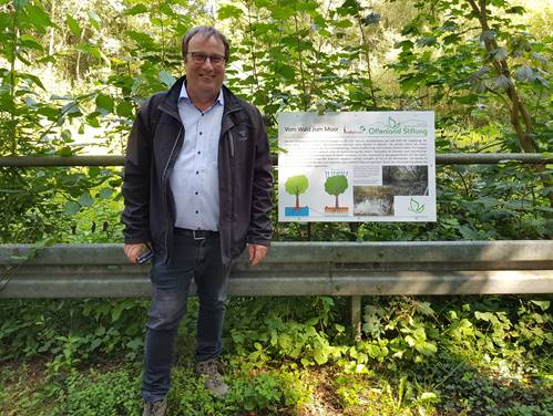 Oliver Krischer am Further Moor neben der Infotafel der Stiftung