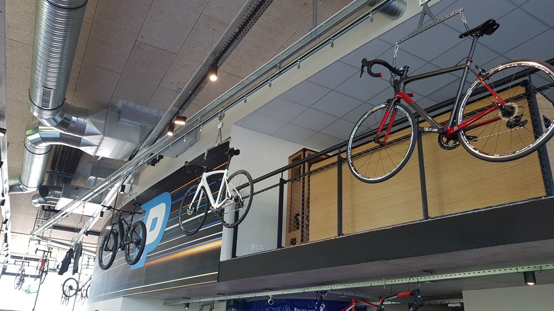 Stockage aérien sur monorail à corde en magasin de cycles pour présentation articles