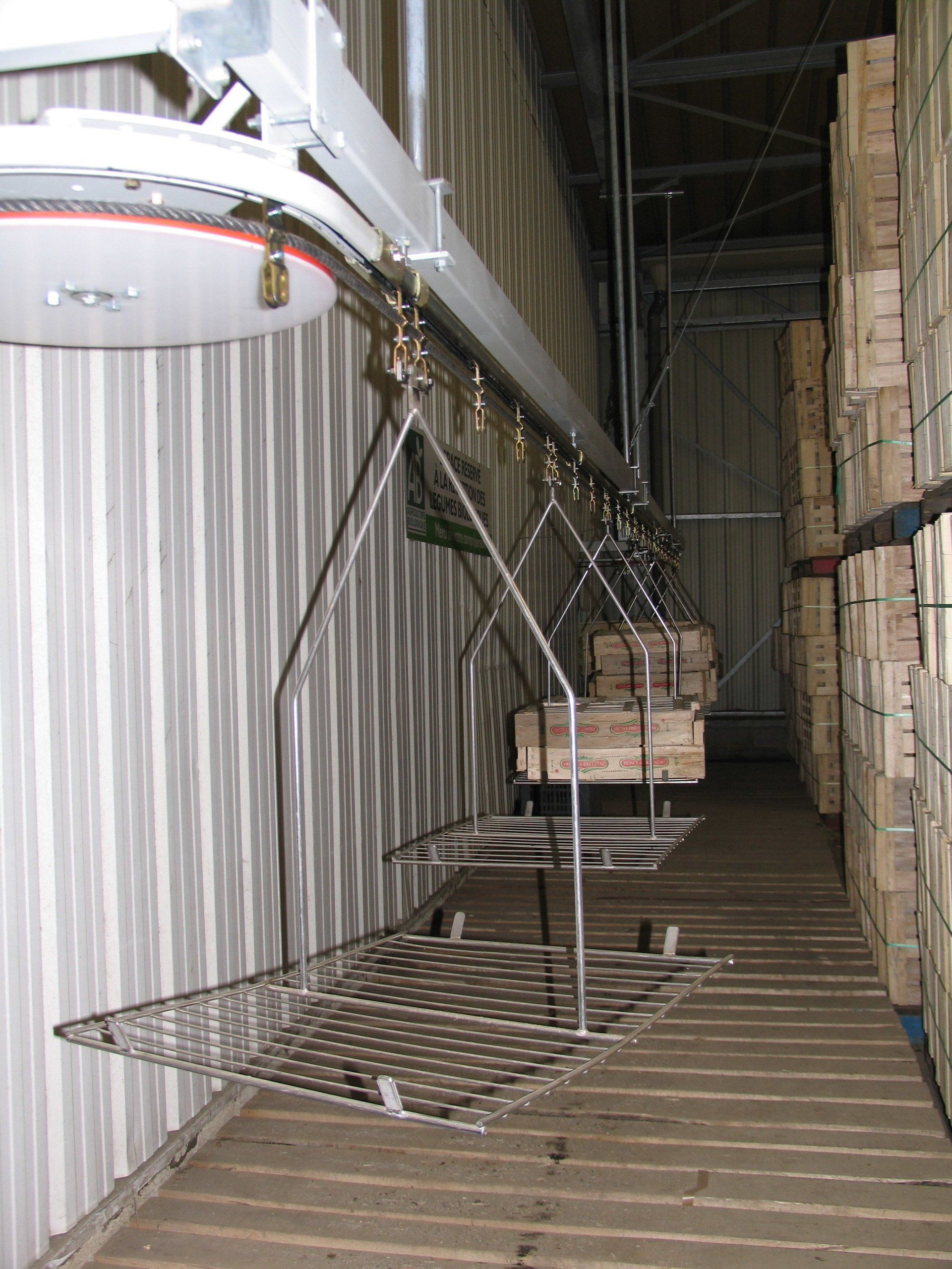 Convoyeur aérien secteur fruits et légumes transport par balancelle de cagette bois multiformat de la zone de stockage emballage aux postes de préparation de commande