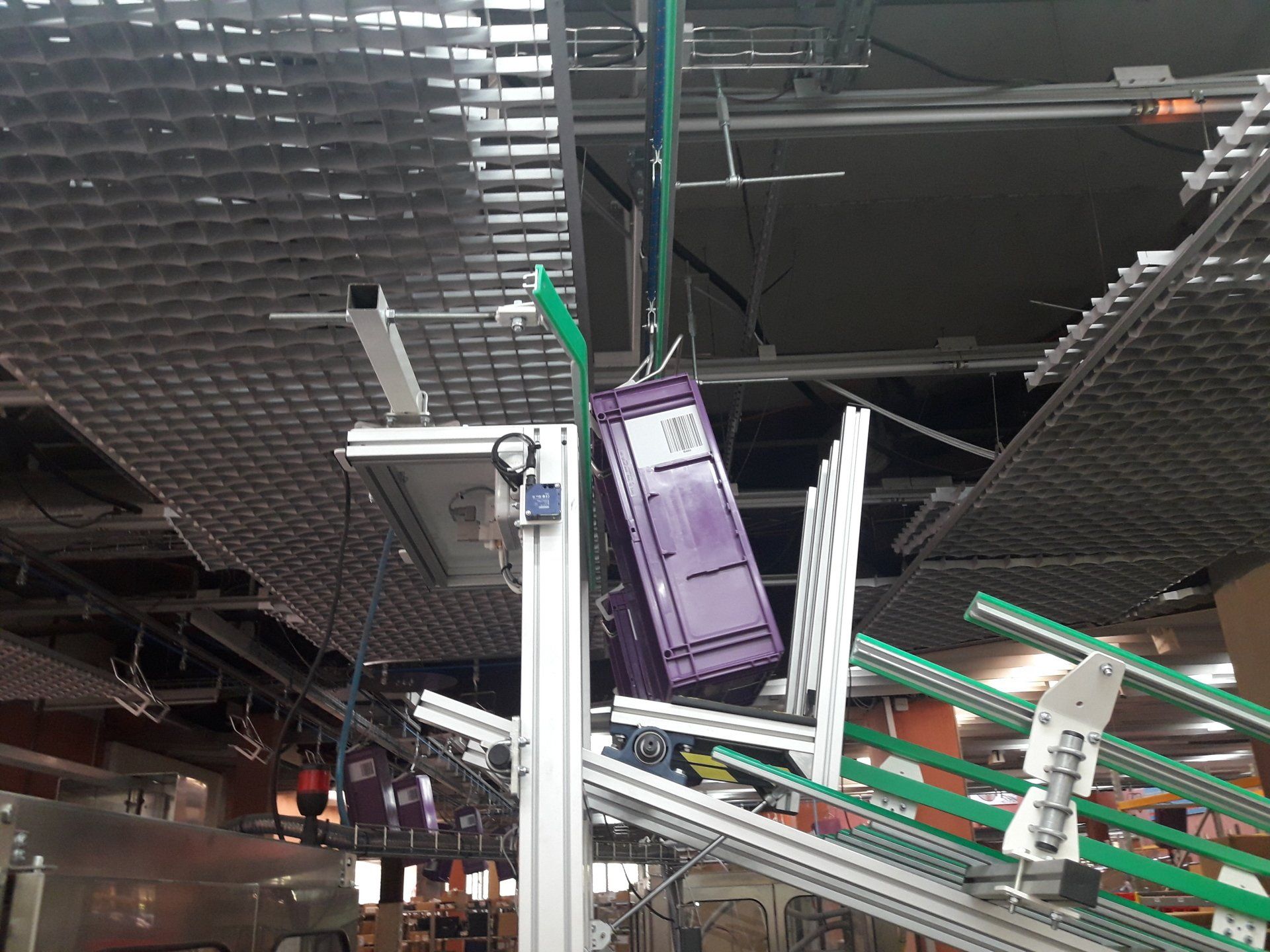 Convoyeur aérien à corde, décrochage automatique des bacs sur toboggan pour préparation de commande