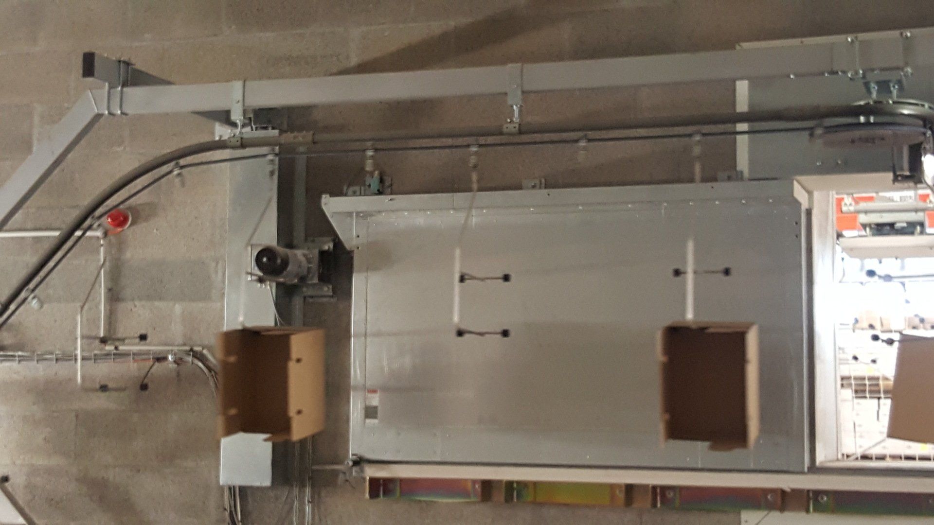 Chargement automatique de cartons sur convoyeur aérien agroalimentaire