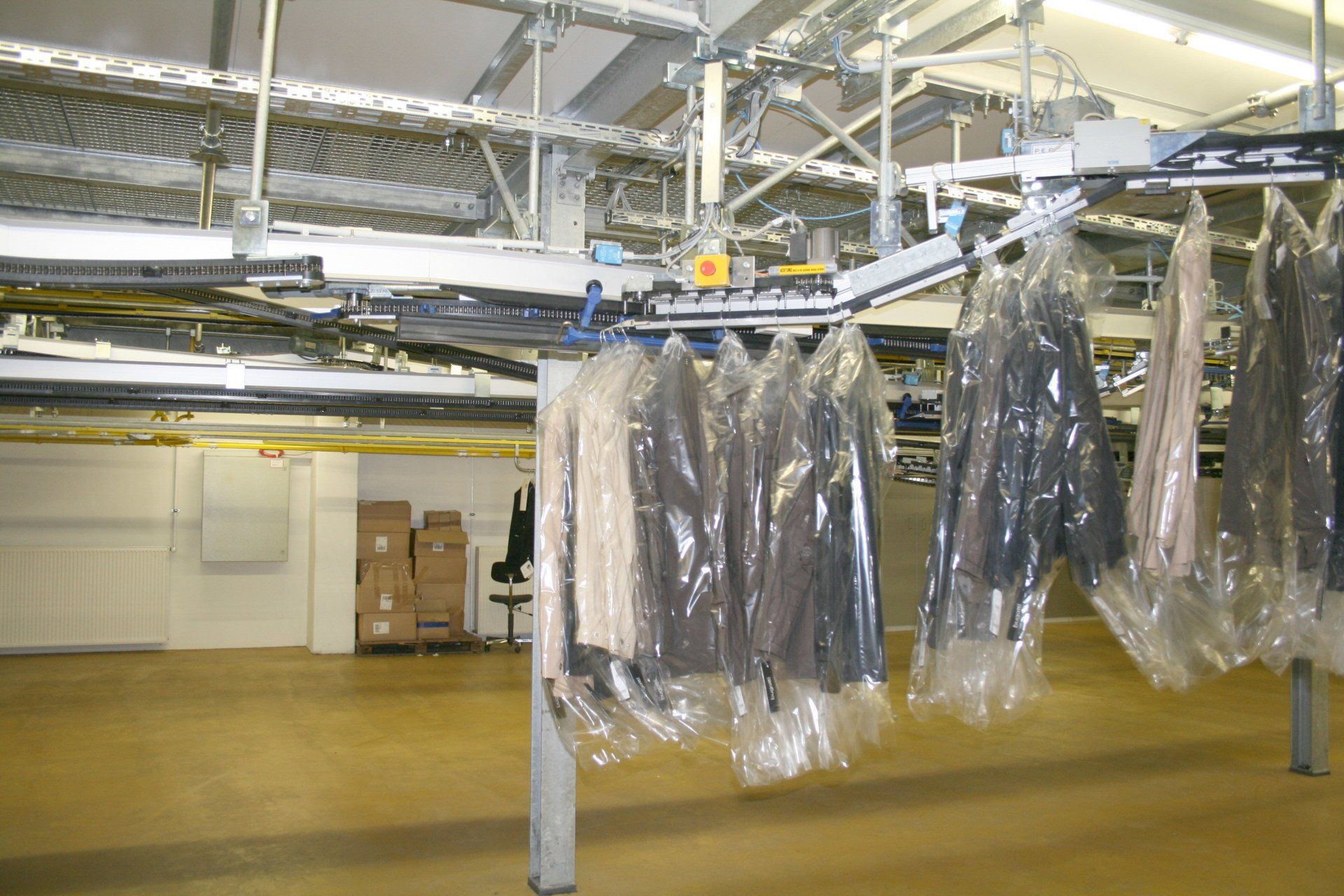 Chargement automatique trolley sur barre en sortie housseuse vêtement sur cintre