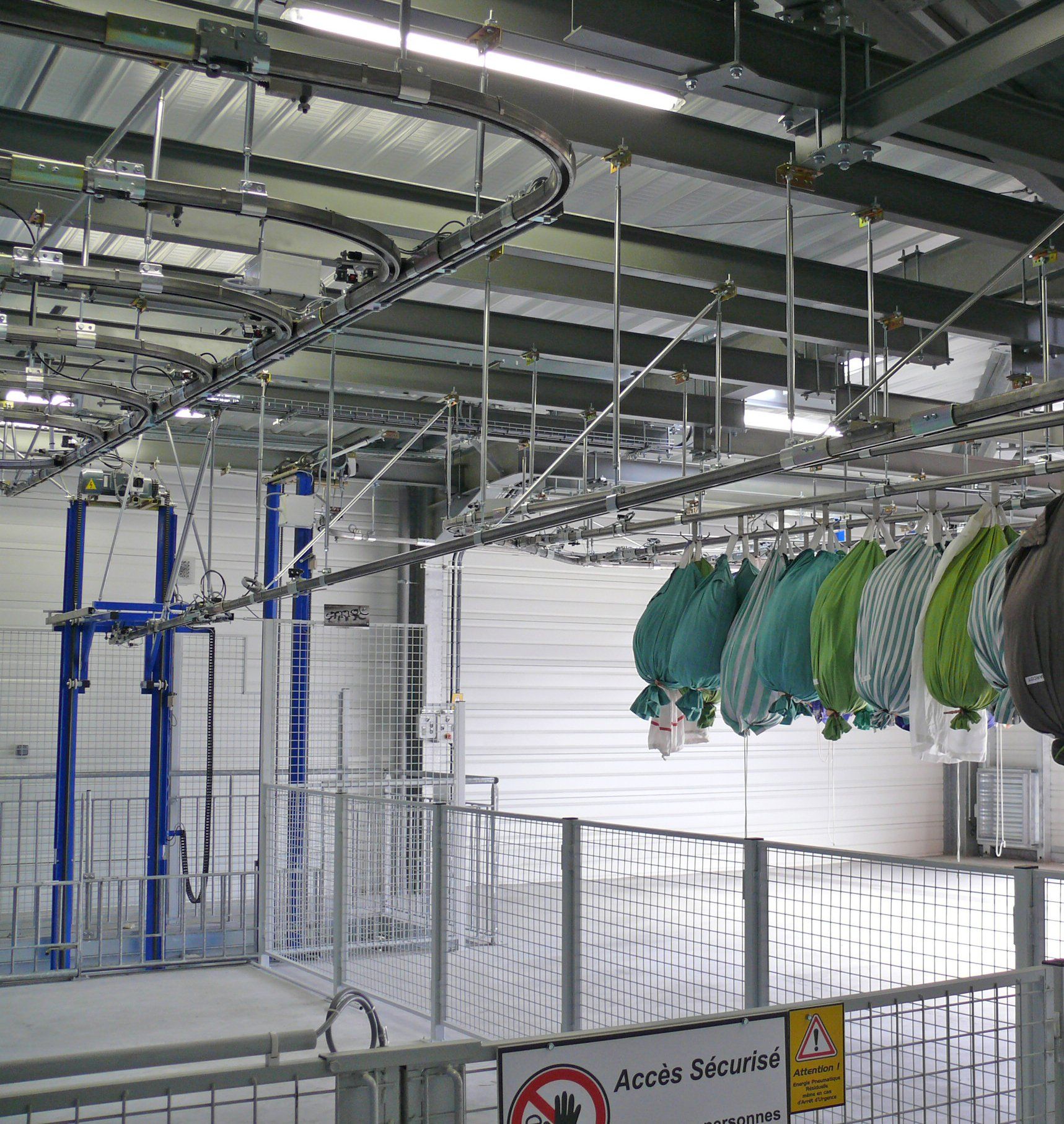 Elévateur sac avec stockage gravitaire en sortie, nappe sacs, trolley crochet double