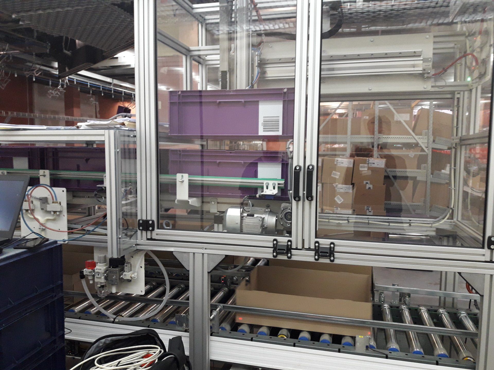 Préparation de commande tenues professionnels, système de déchargement bacs sur table à rouleau