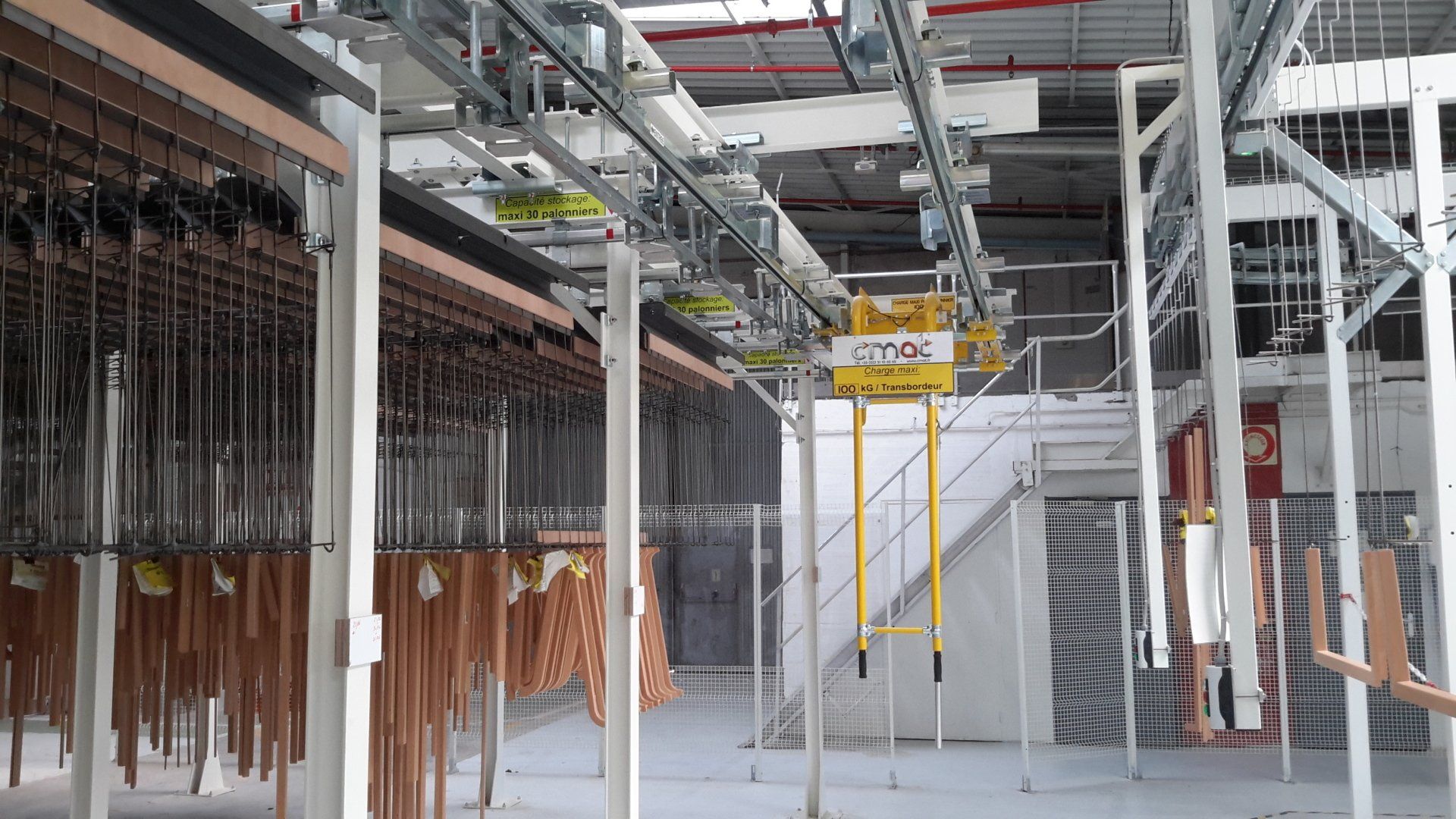 Convoyeur aérien pour transfert en cabine de vernissage des pièces bois via un transbordeur