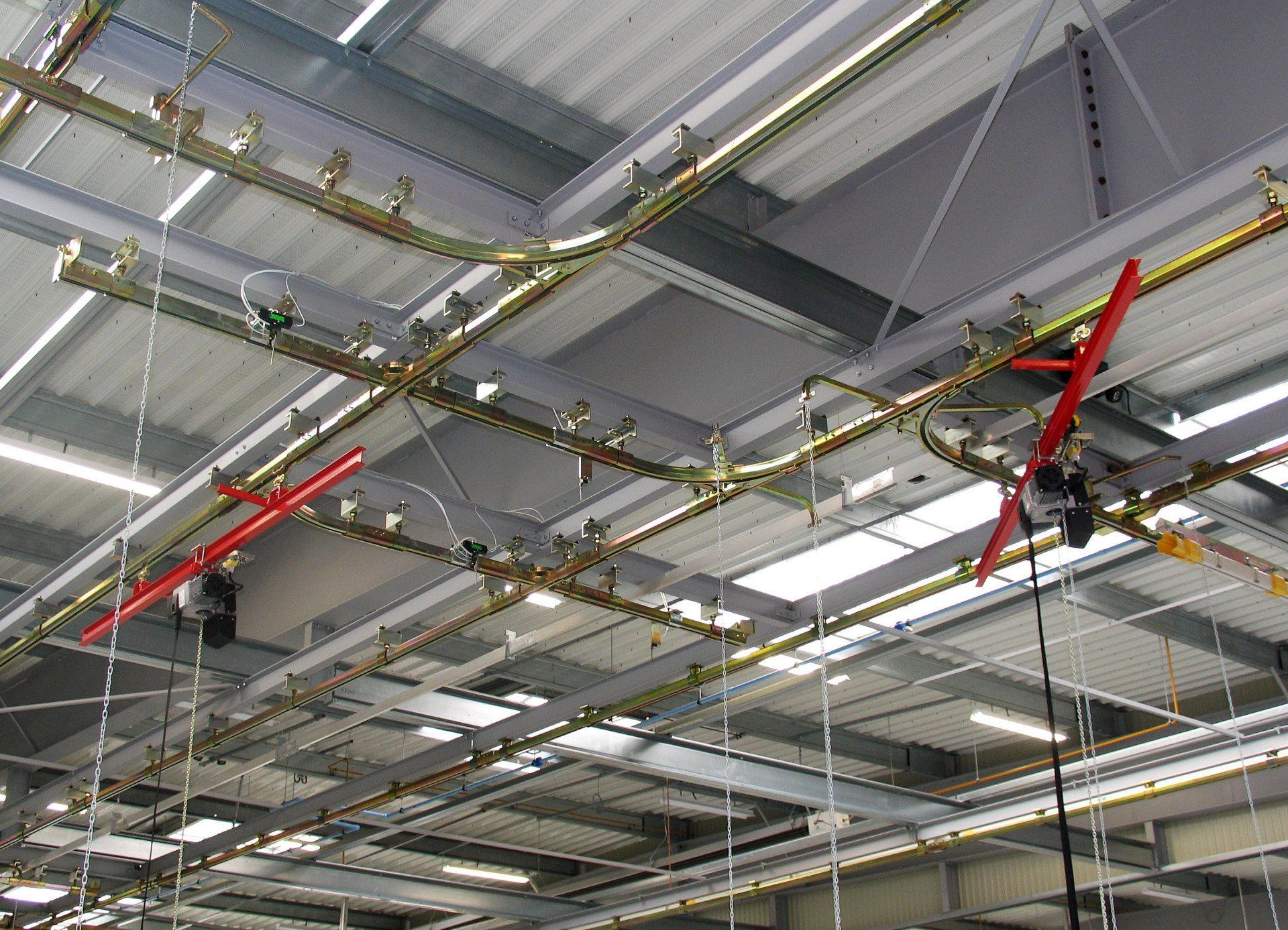 Convoyeur aérien pour couverture de surface avec aiguillages et système de levage, manutention manuelle de poste à poste