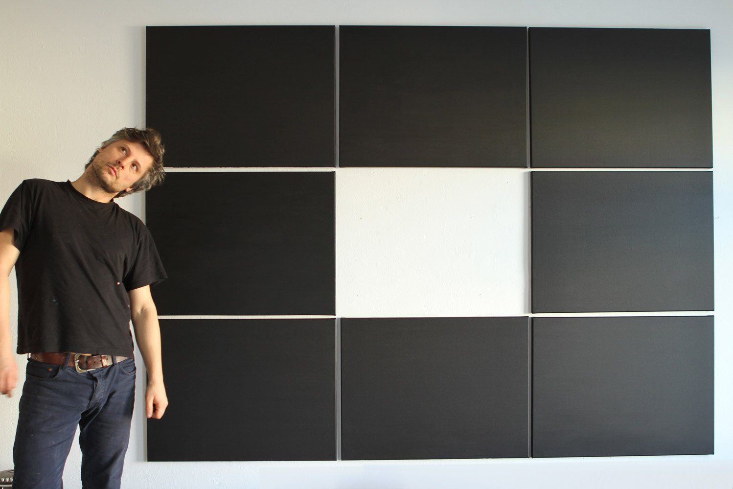 Artist Sebastian Bieniek posing with his work 