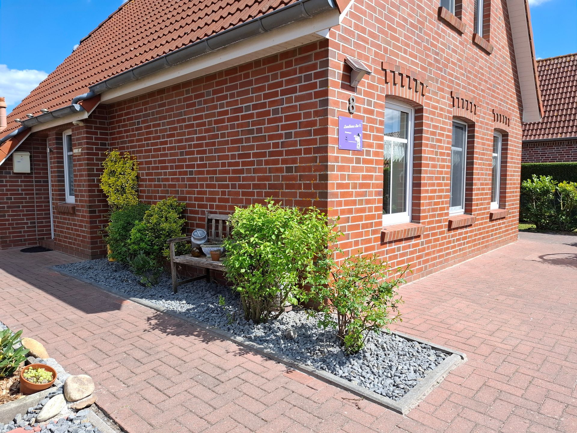 Ansicht Ferienhaus Leo 2 Greetsiel vom Garten mit Blick auf Terasse, Parkplatz inkl. Pflanzen