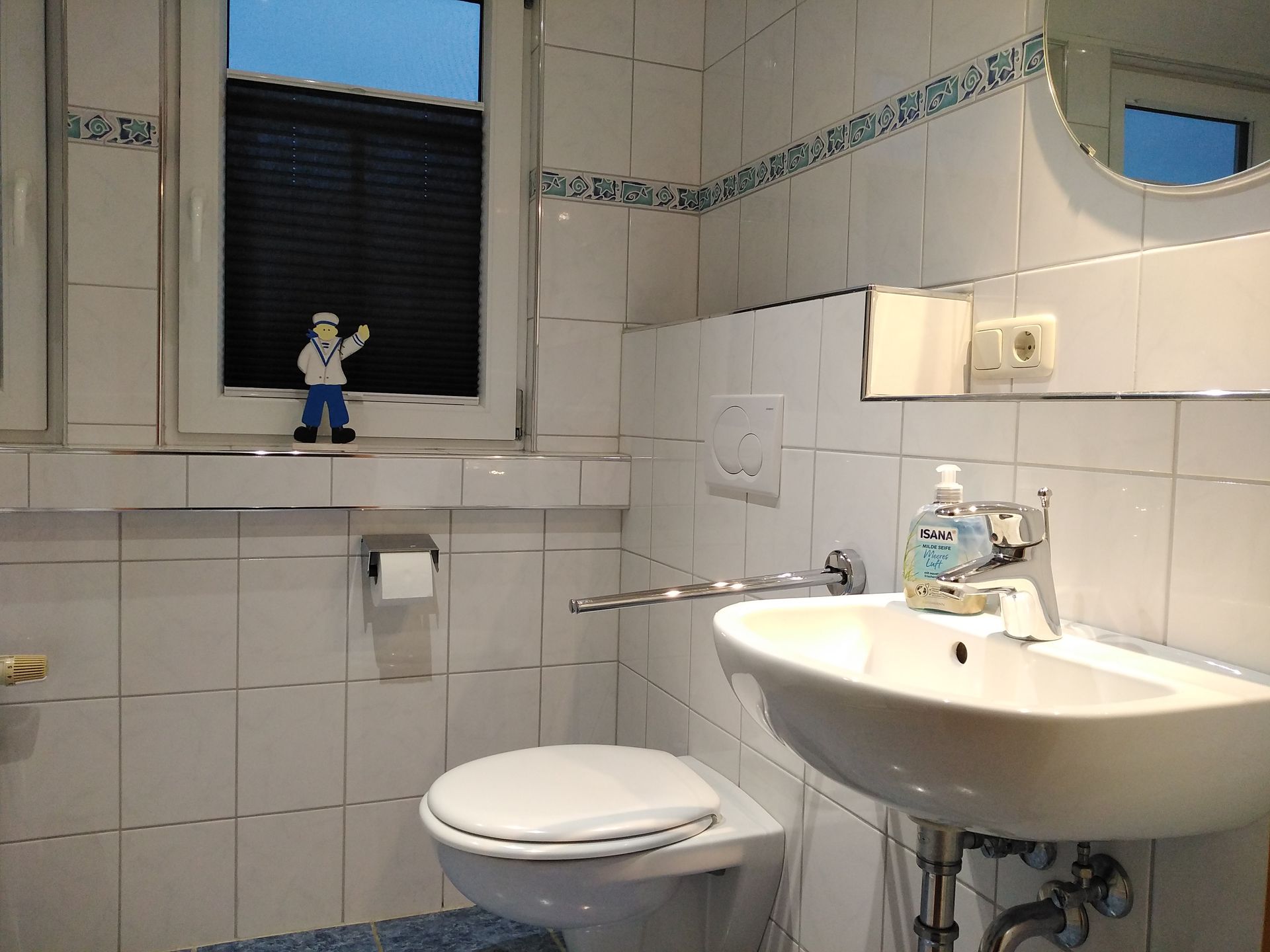 Badezimmer Waschbecken im OG Ferienhaus Leo 2 Greetsiel mit Verdunkelung und Deko Matrosen