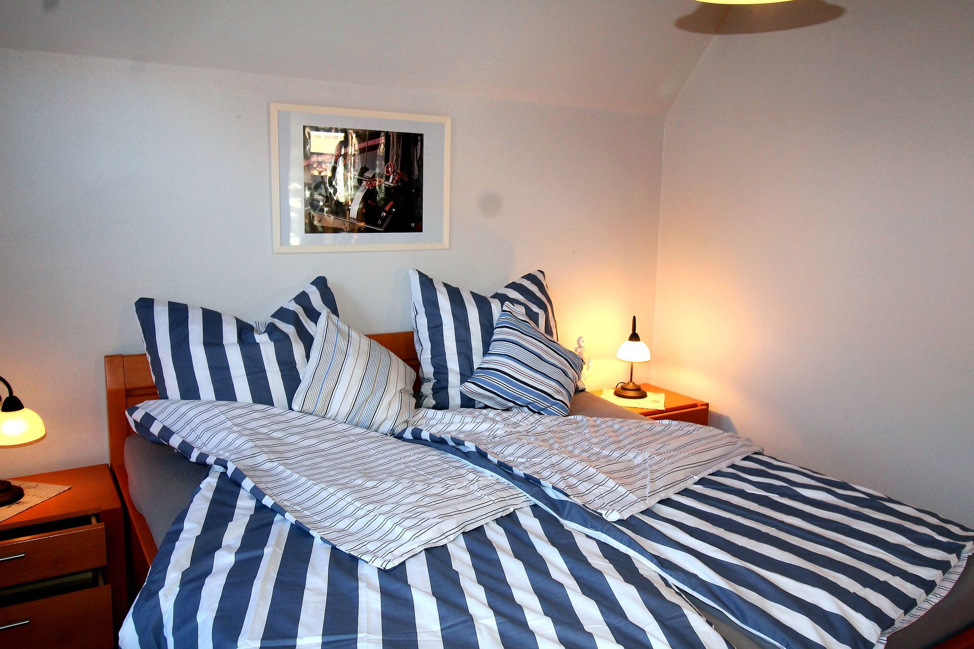 Schlafzimmer Ferienhaus Landhaus Leo 2 mit gestreifter Bettwäsche