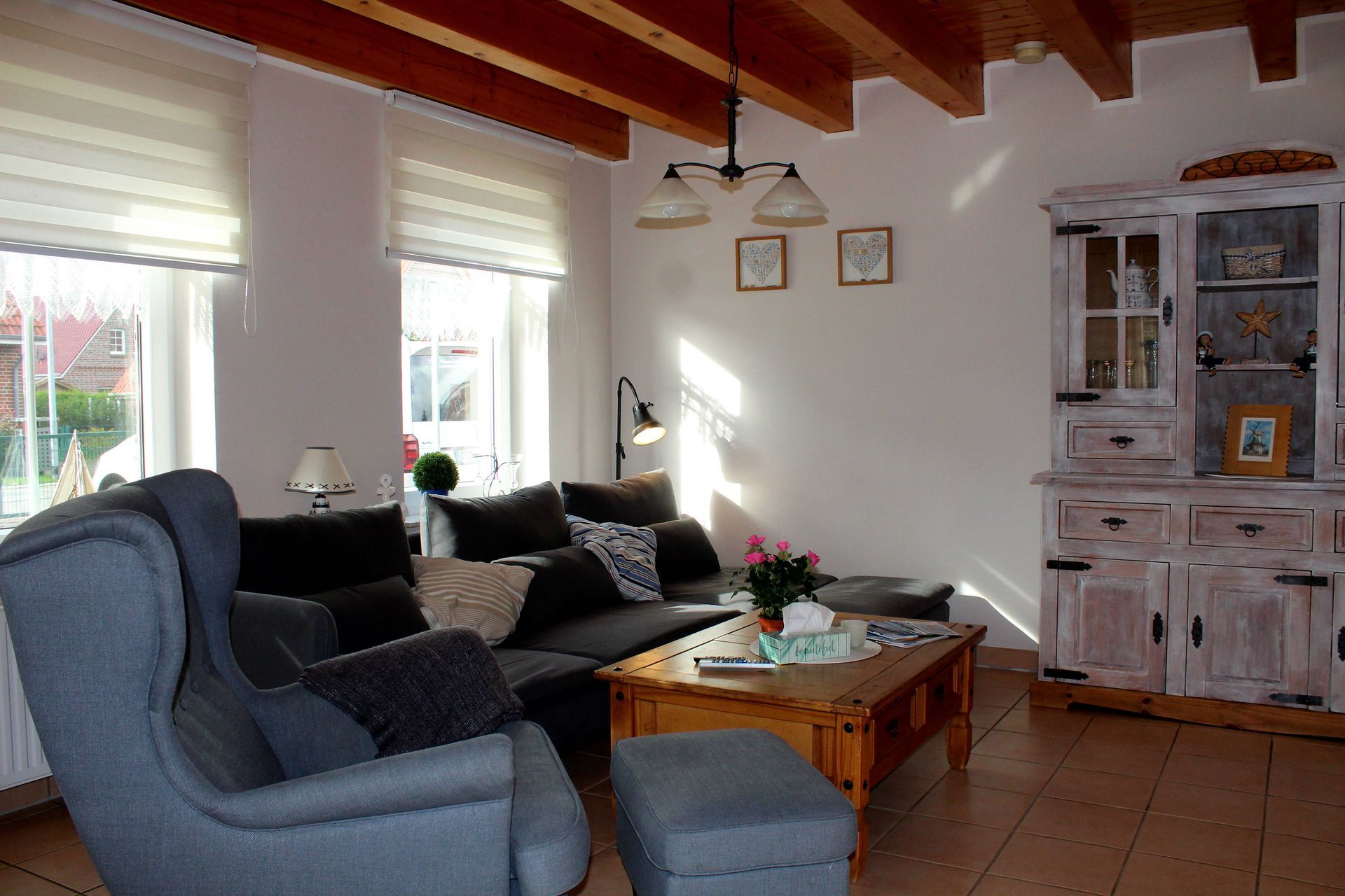 Wohnzimmer mit weißem Bauernschrank Ferienhaus Leo 2 Greetsiel
