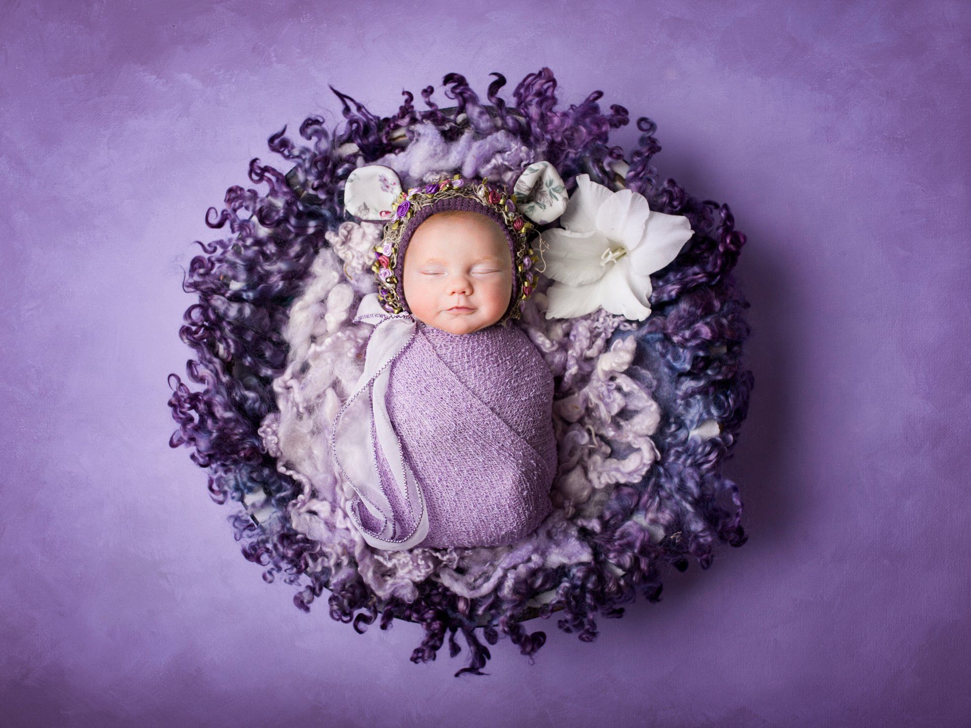 Baby schlafend in lila Blumenkorb