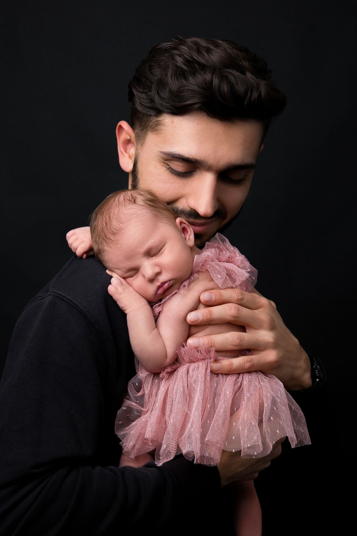 Vater und Baby vor schwarzem Hintergrund