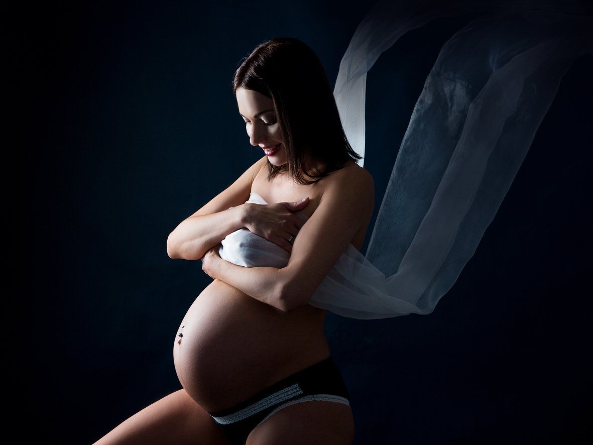 Schwangerschaftsfotos vor blau mit wehendem Schal