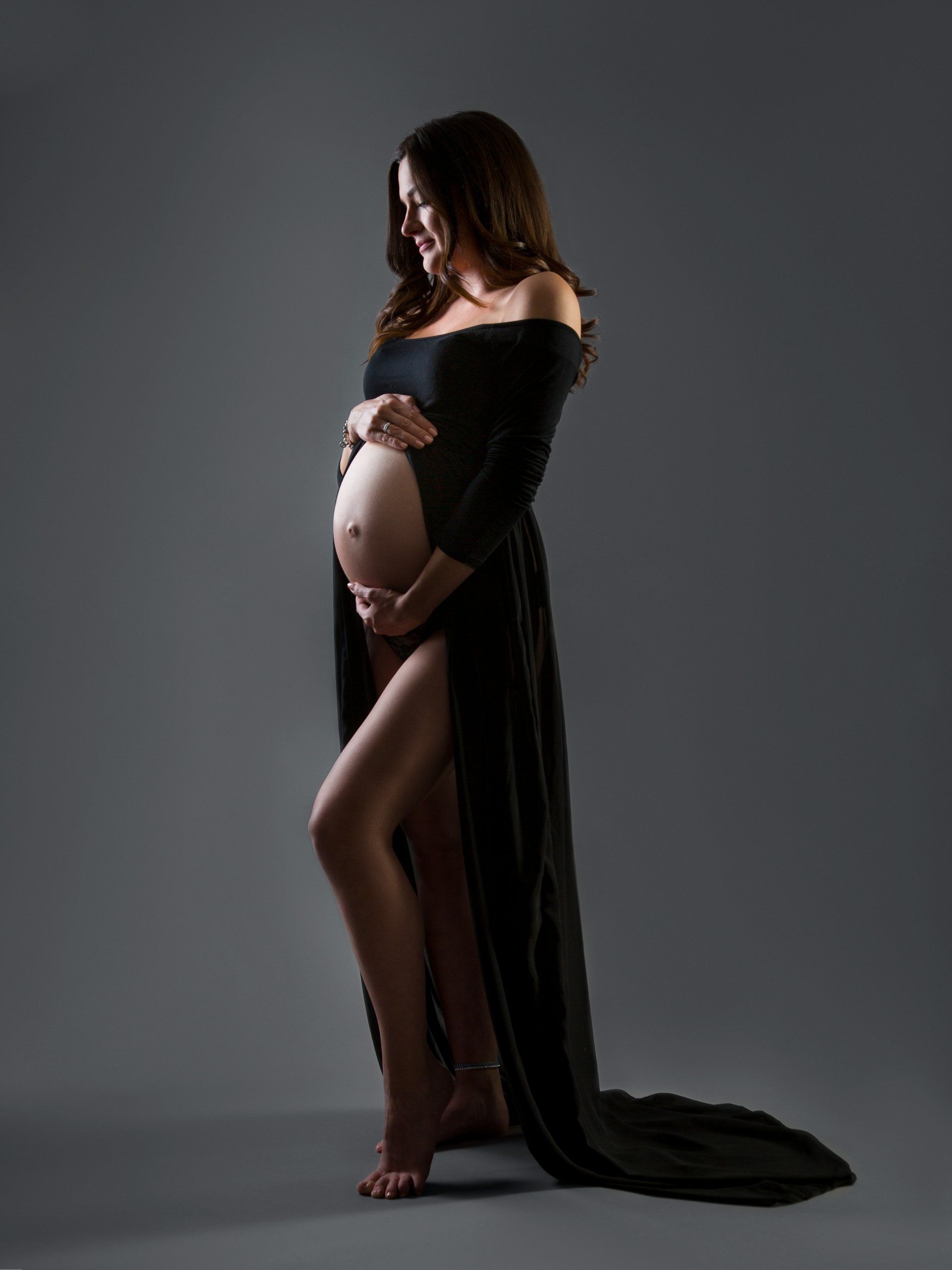 Schwangerschaft und Babybauch vor grau