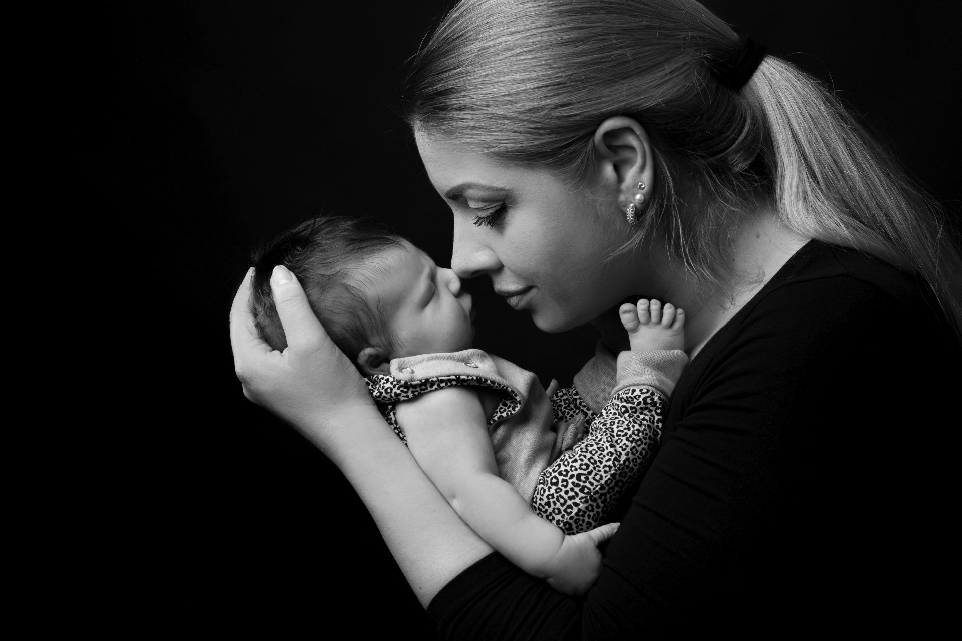 Mama mit neugeborenem Baby im Arm schwarz weiß