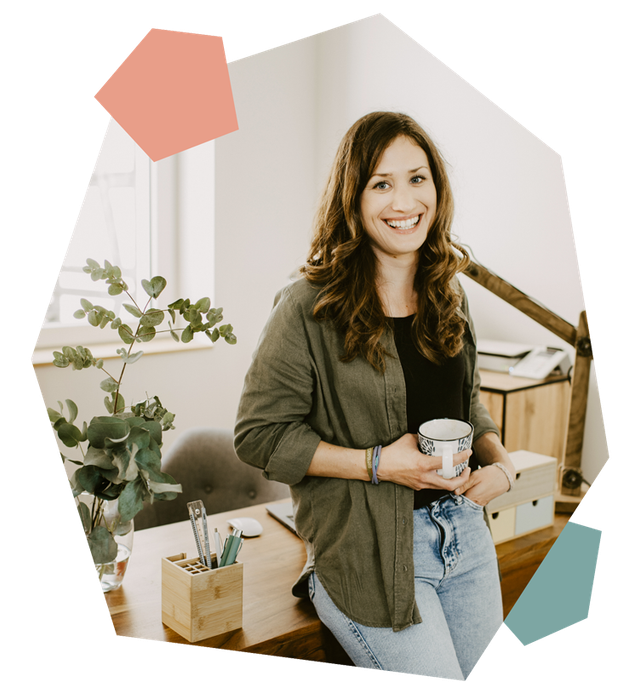 Christina Herzog Christina Herzog lehnt am Schreibtisch